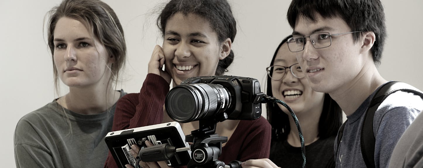 Four students excitedly aim a camera