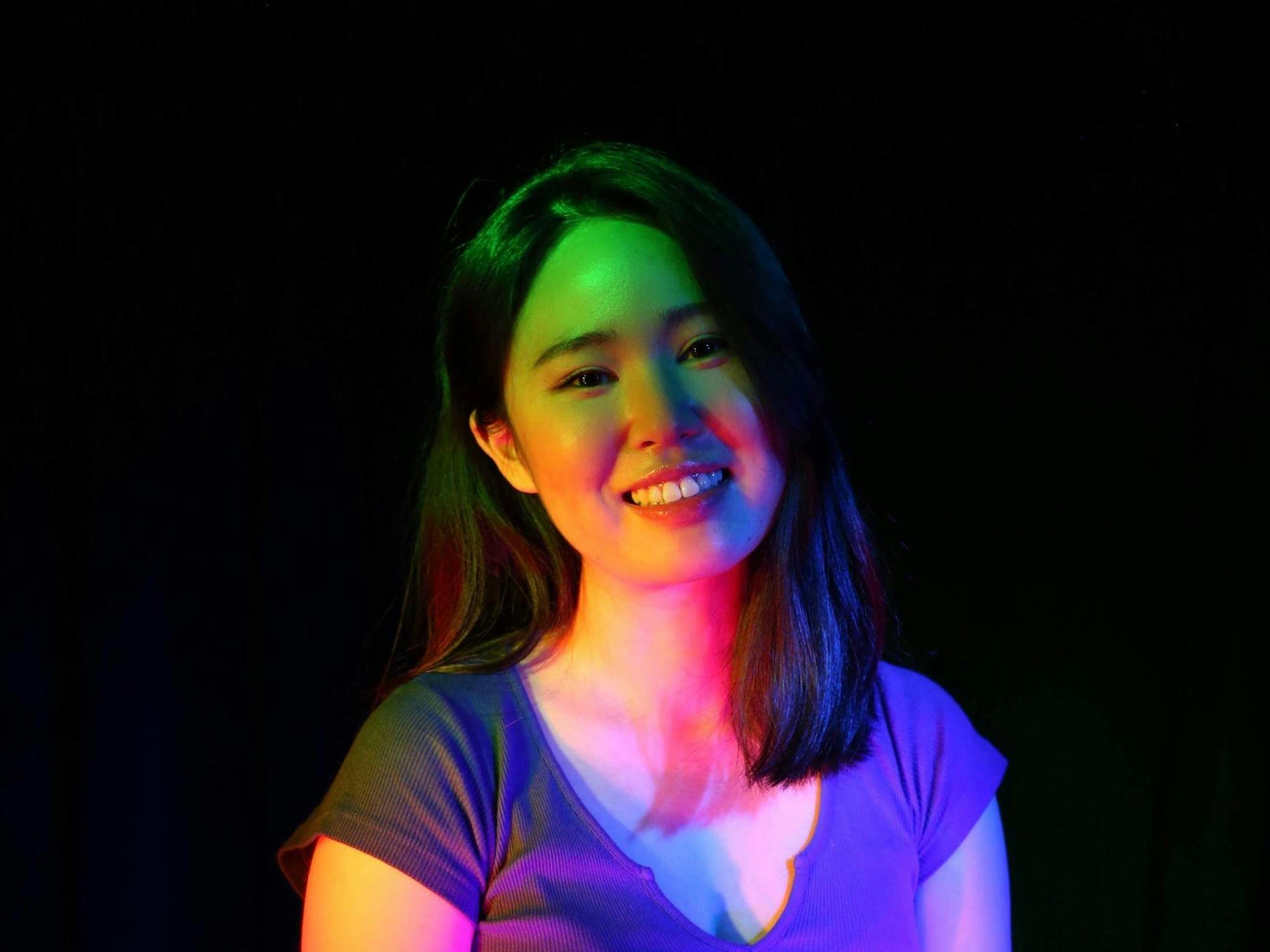 Women smiling under multi-colored spotlight