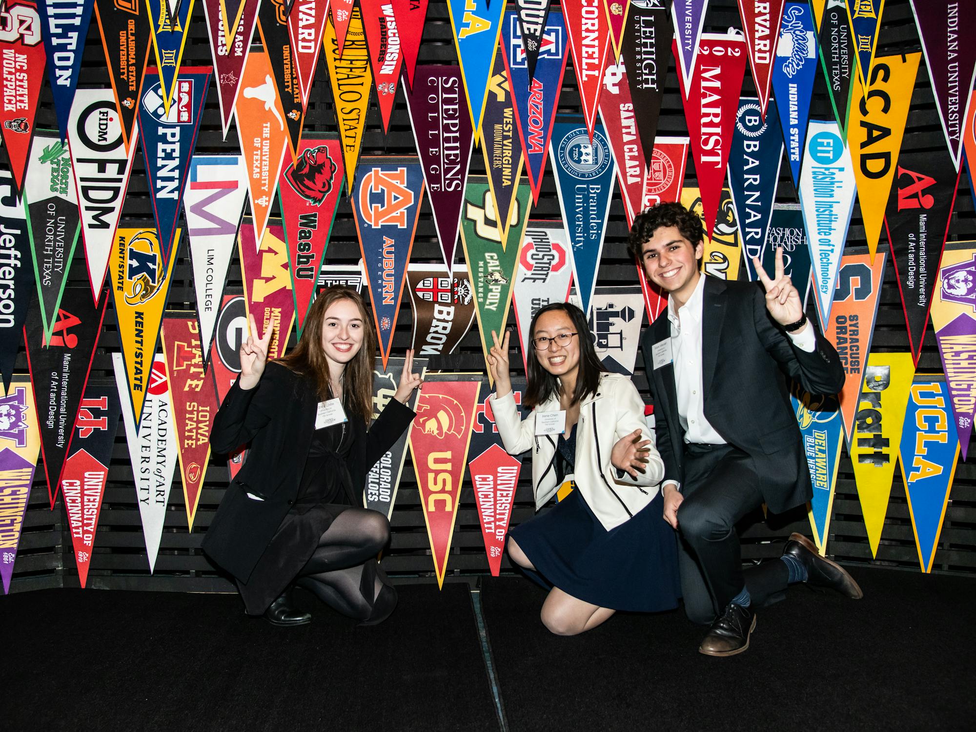 Students standing in front of a wall of school flags