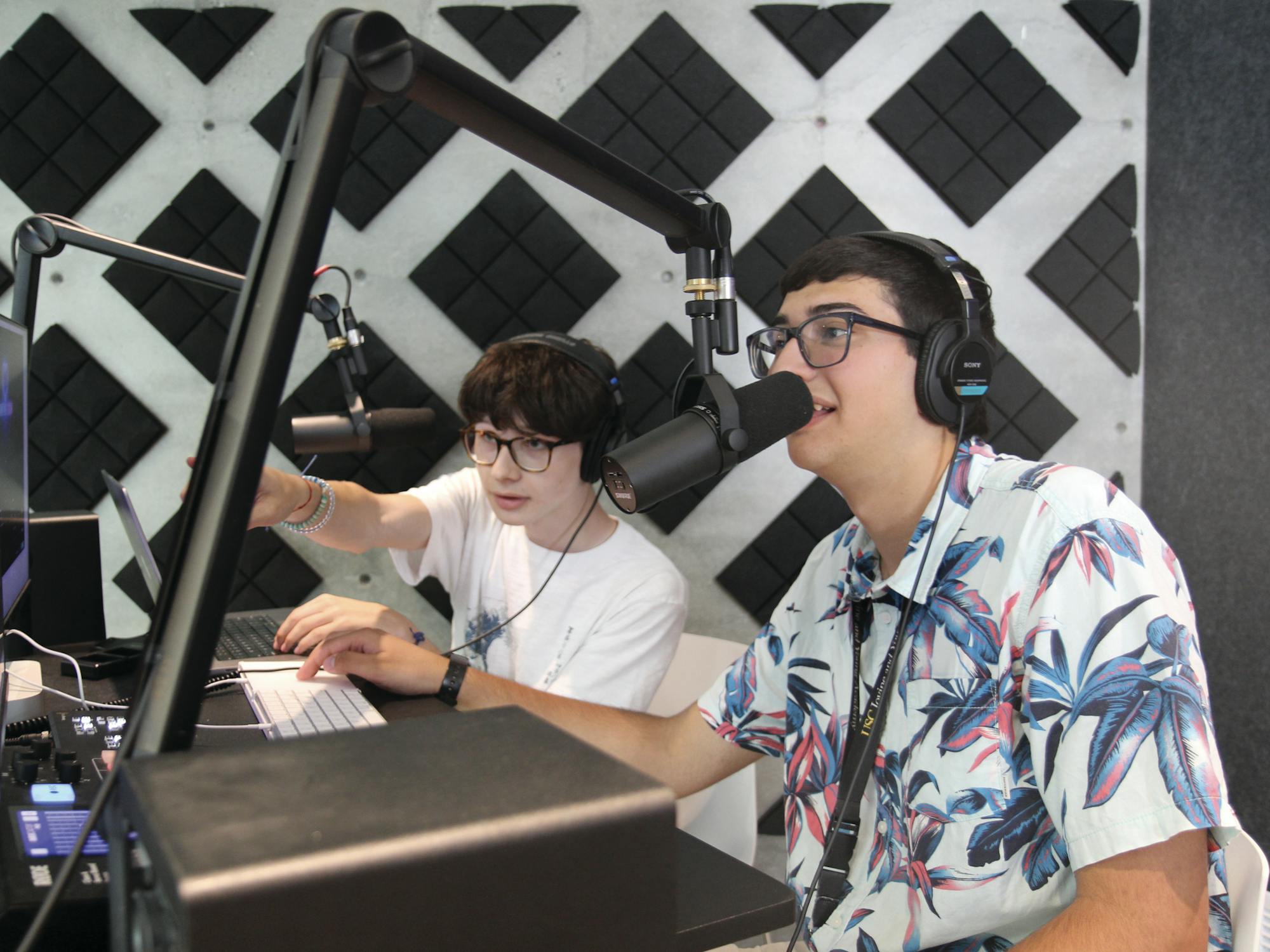 two people on a microphones in a podcast studio with audio equipment 