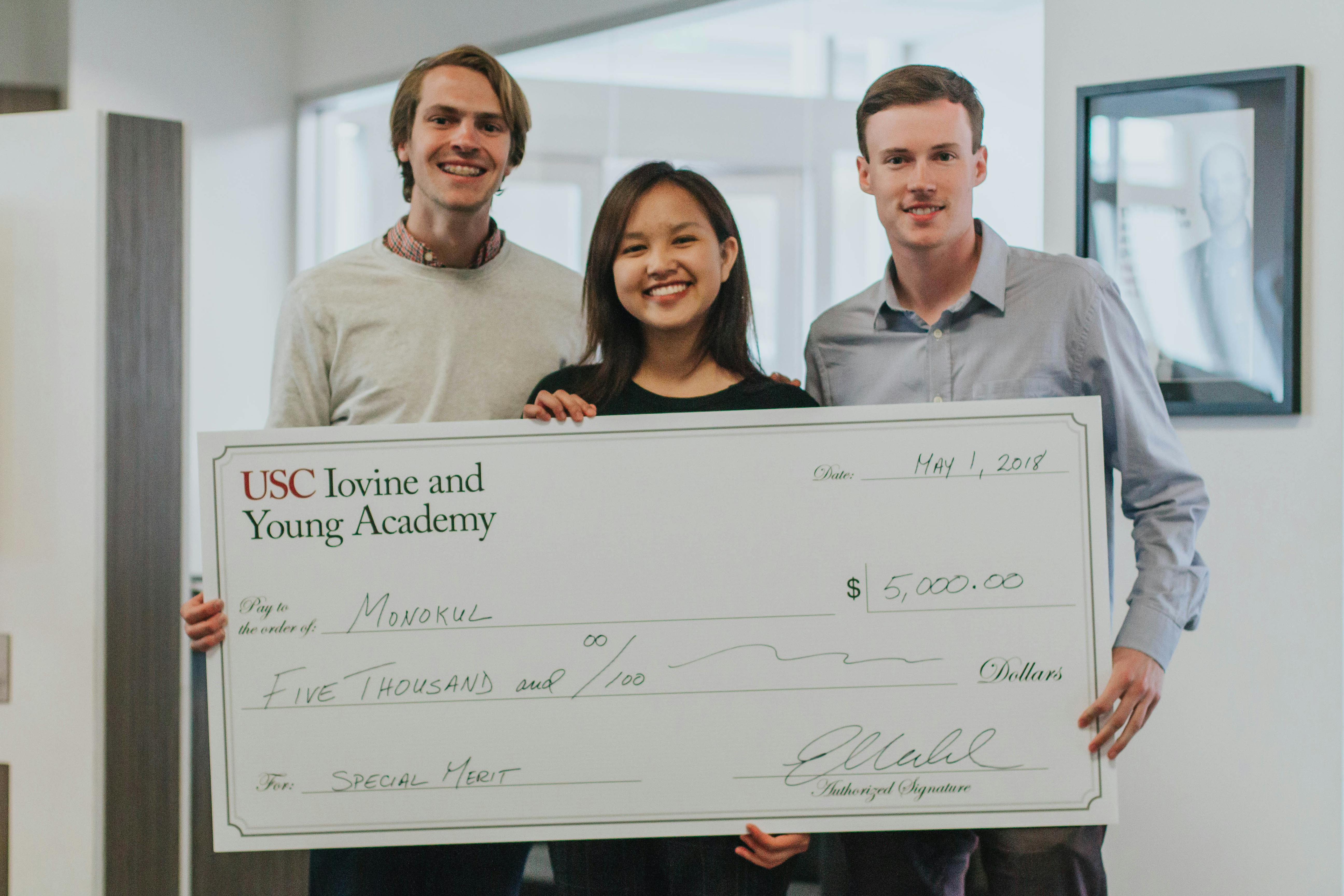 3 students holding giant check