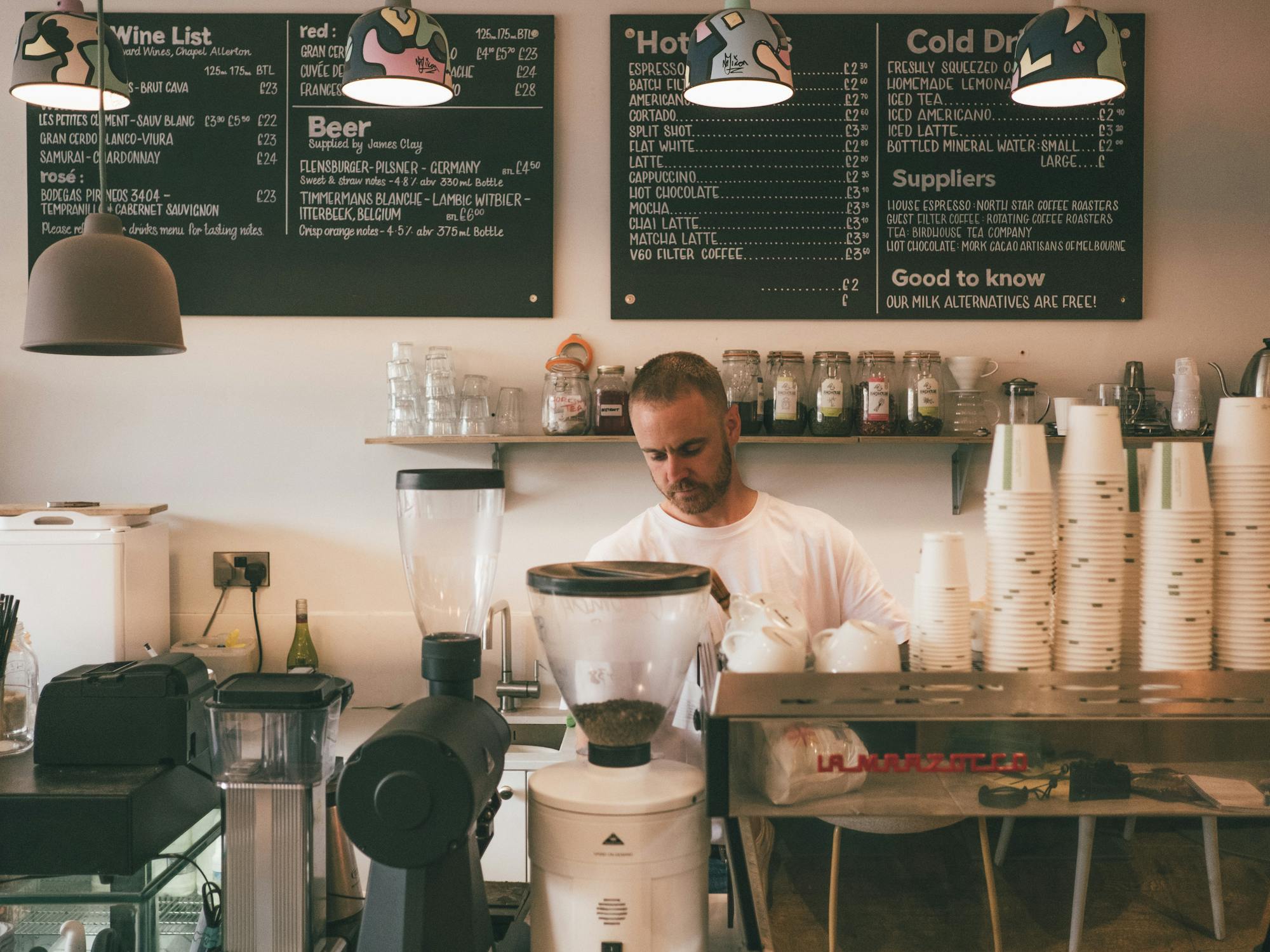 Barista preparing coffee behind counter in cafe