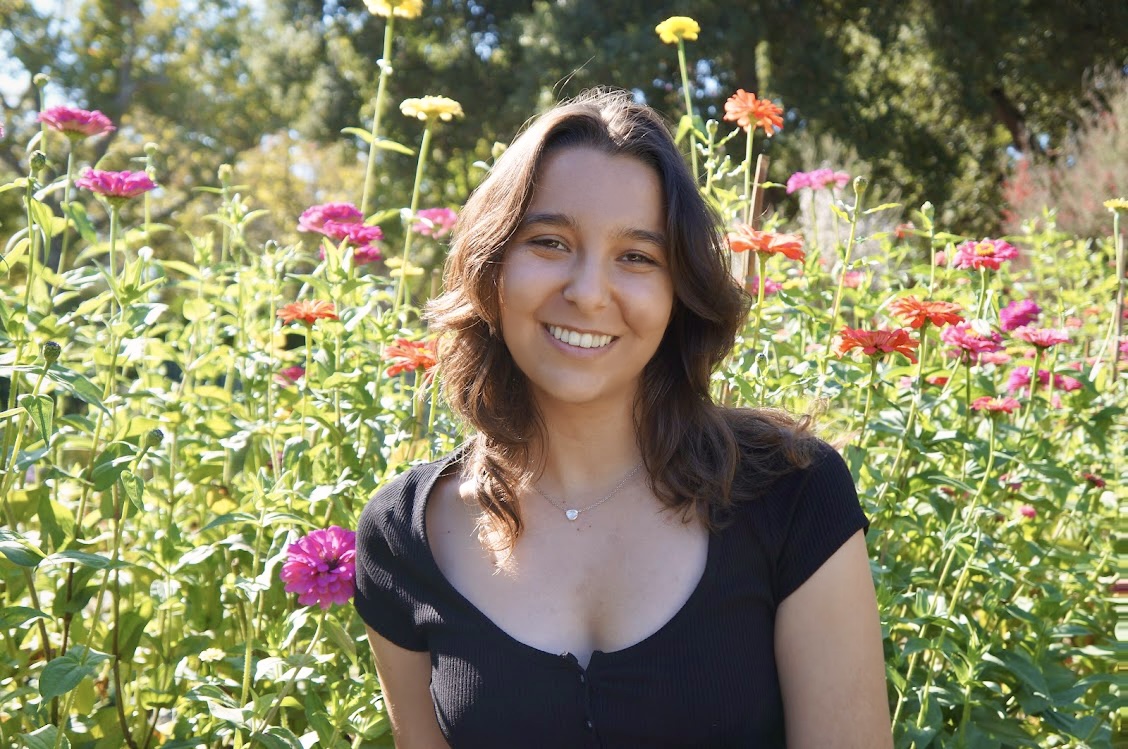 Young woman in a black top in a field of colorful flowers. 