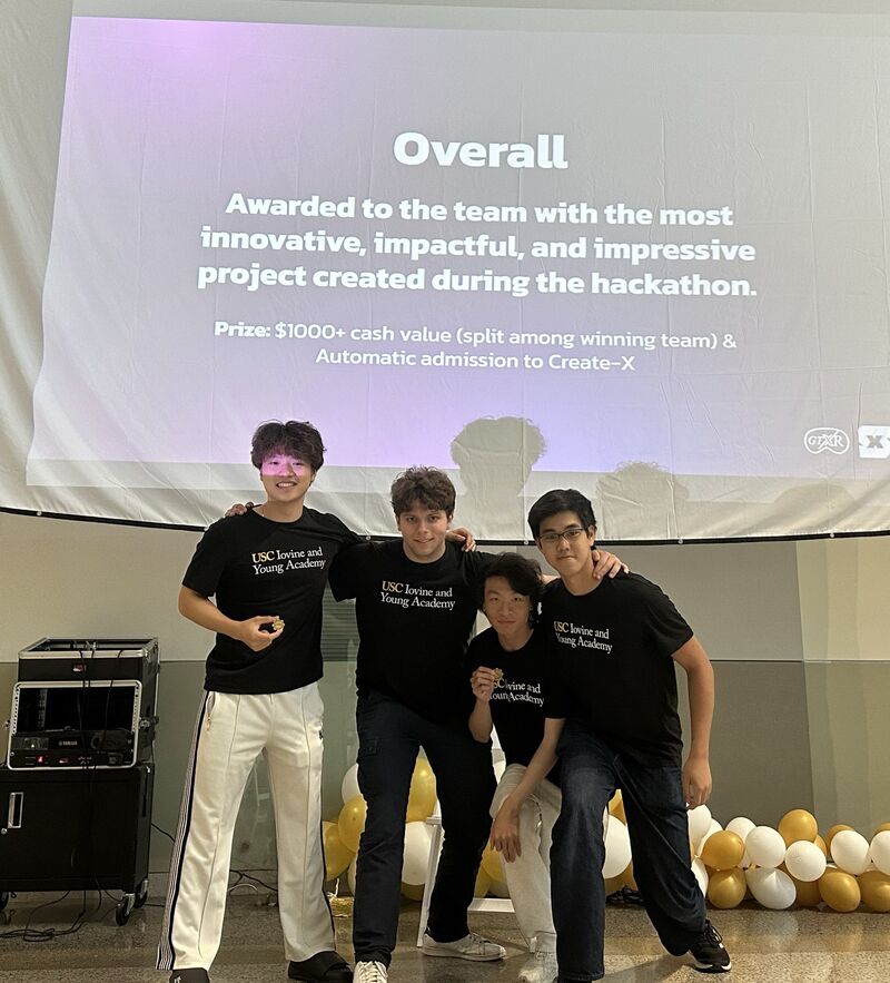 Four students in front of winning presentation screen. 
