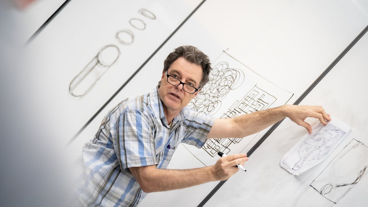 Professor instructing in front of white board
