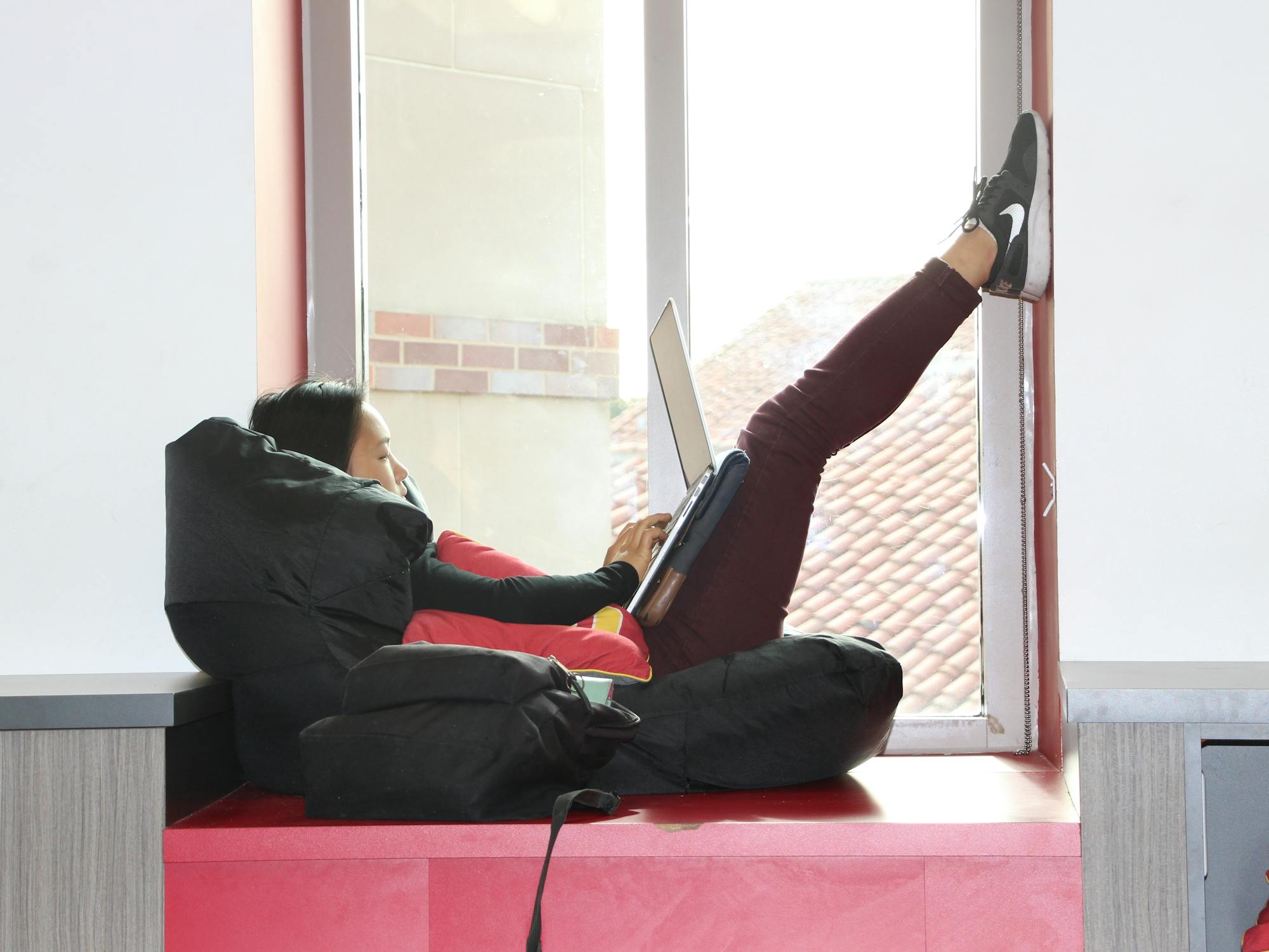 Person with laptop at a window in a school