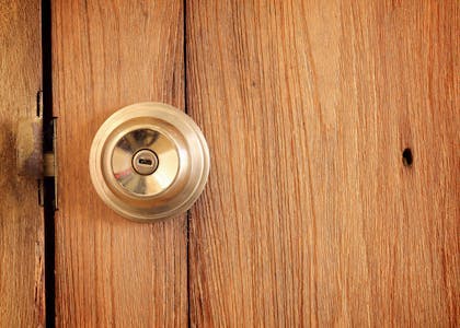 An image of a door knob on a wooden door