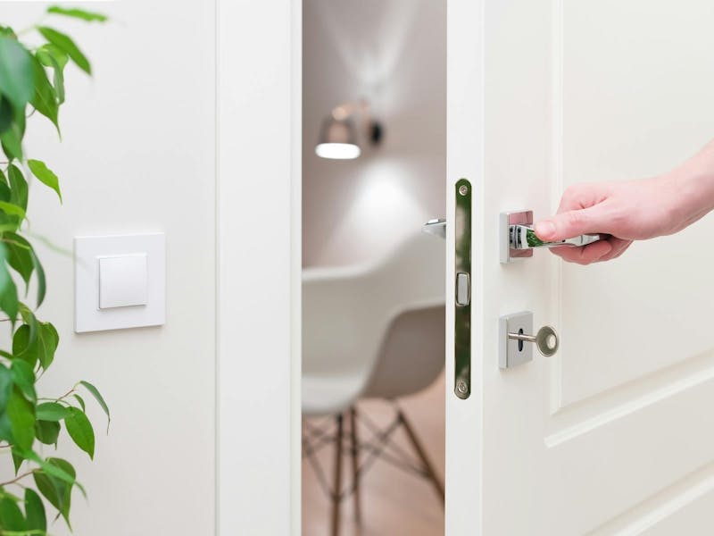 An image of a silver door lock on a white door
