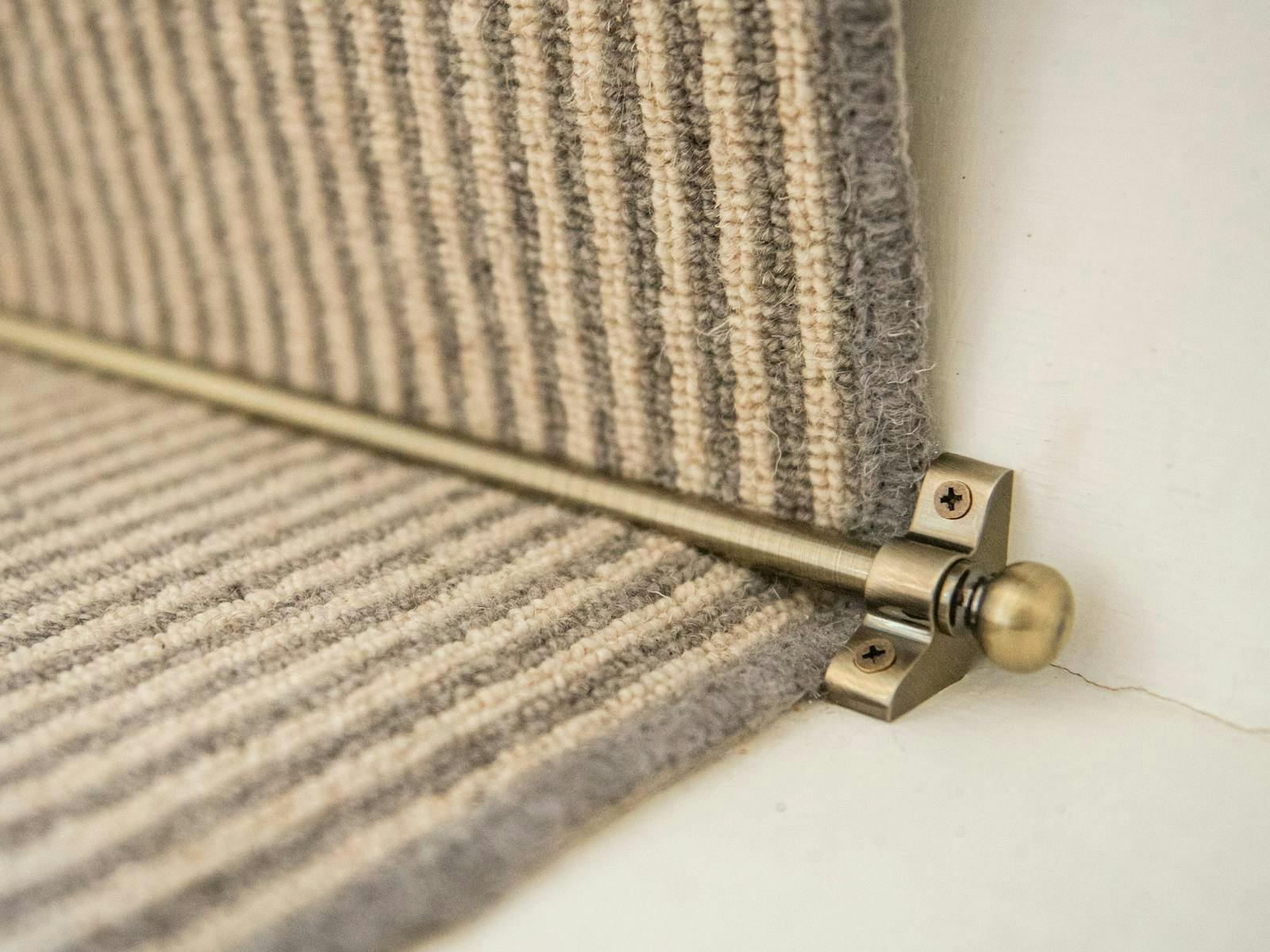 A close up image of gold stair rods