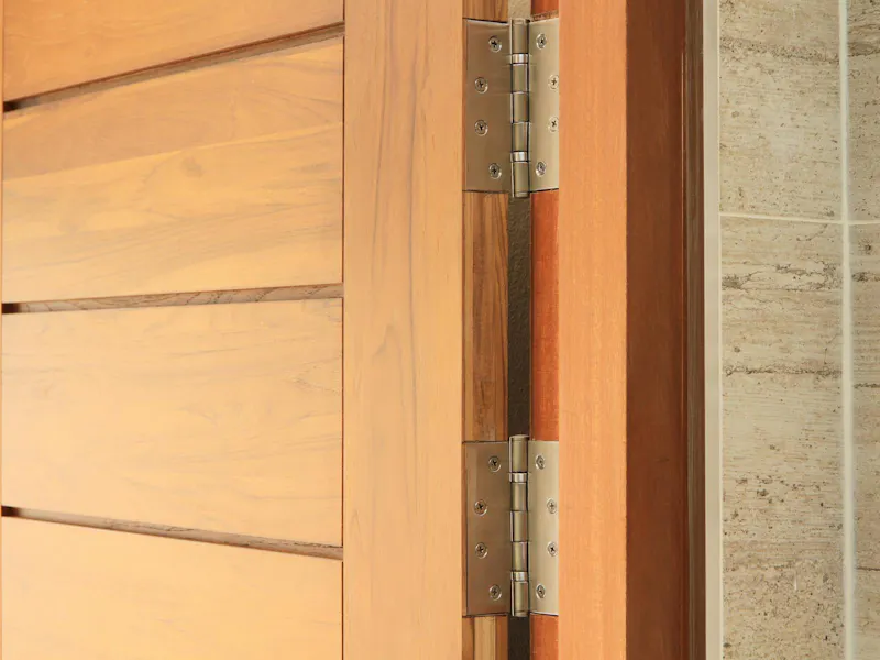 An image of a hinge on a wooden door