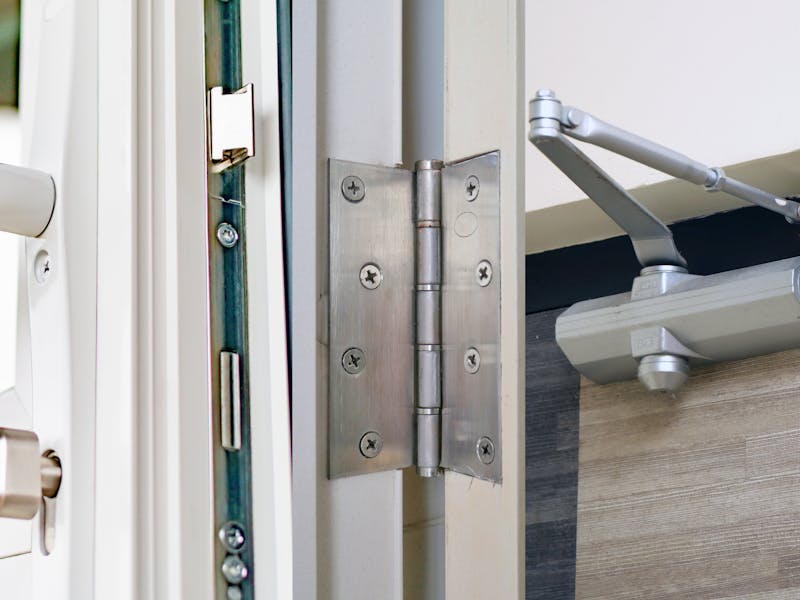 An image of a door lock, hinge, and closer