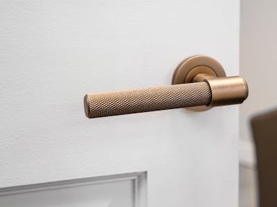 An image of a door handle on a white door