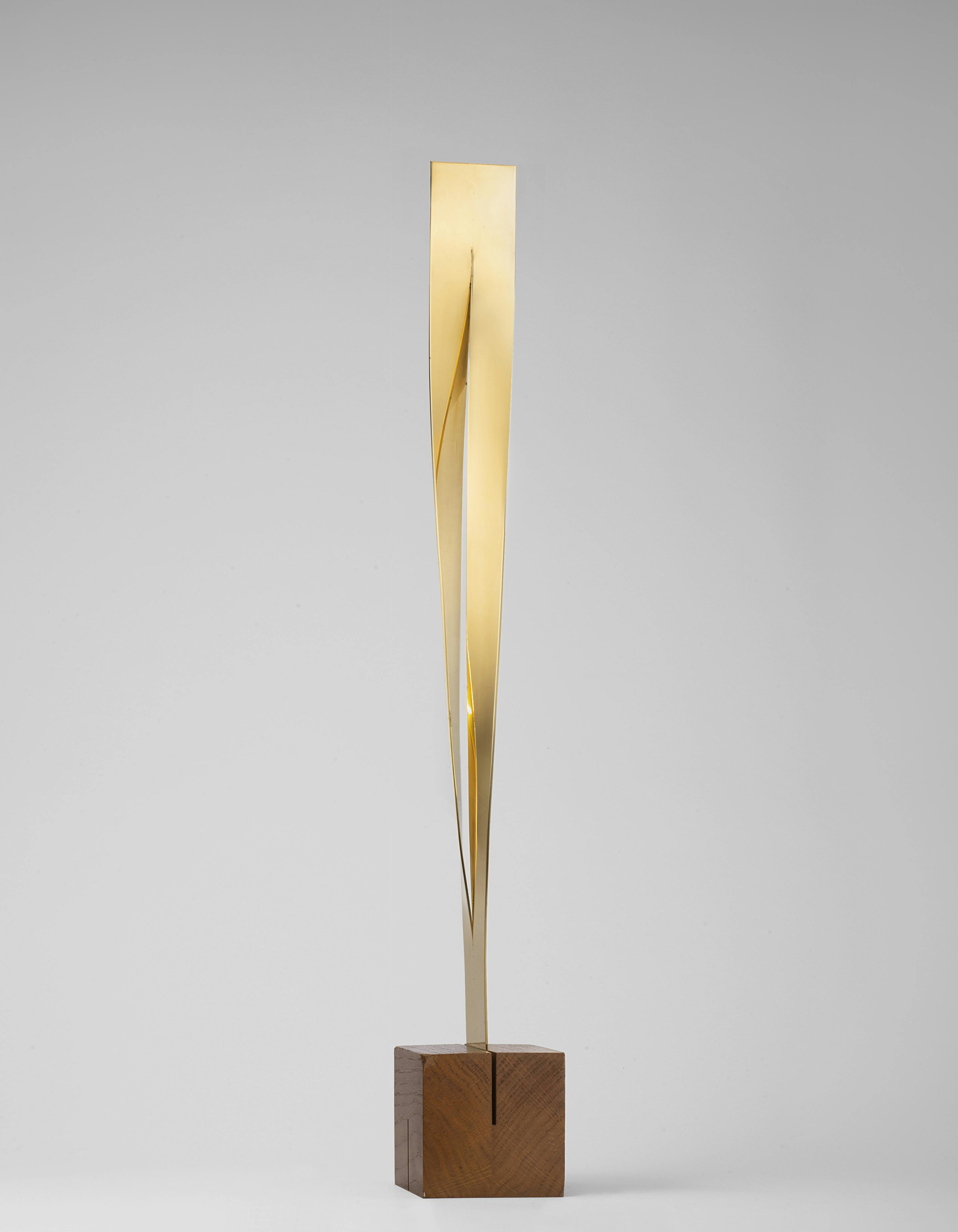 Photograph of a geometric, gold-colored sculpture by Max Bill.