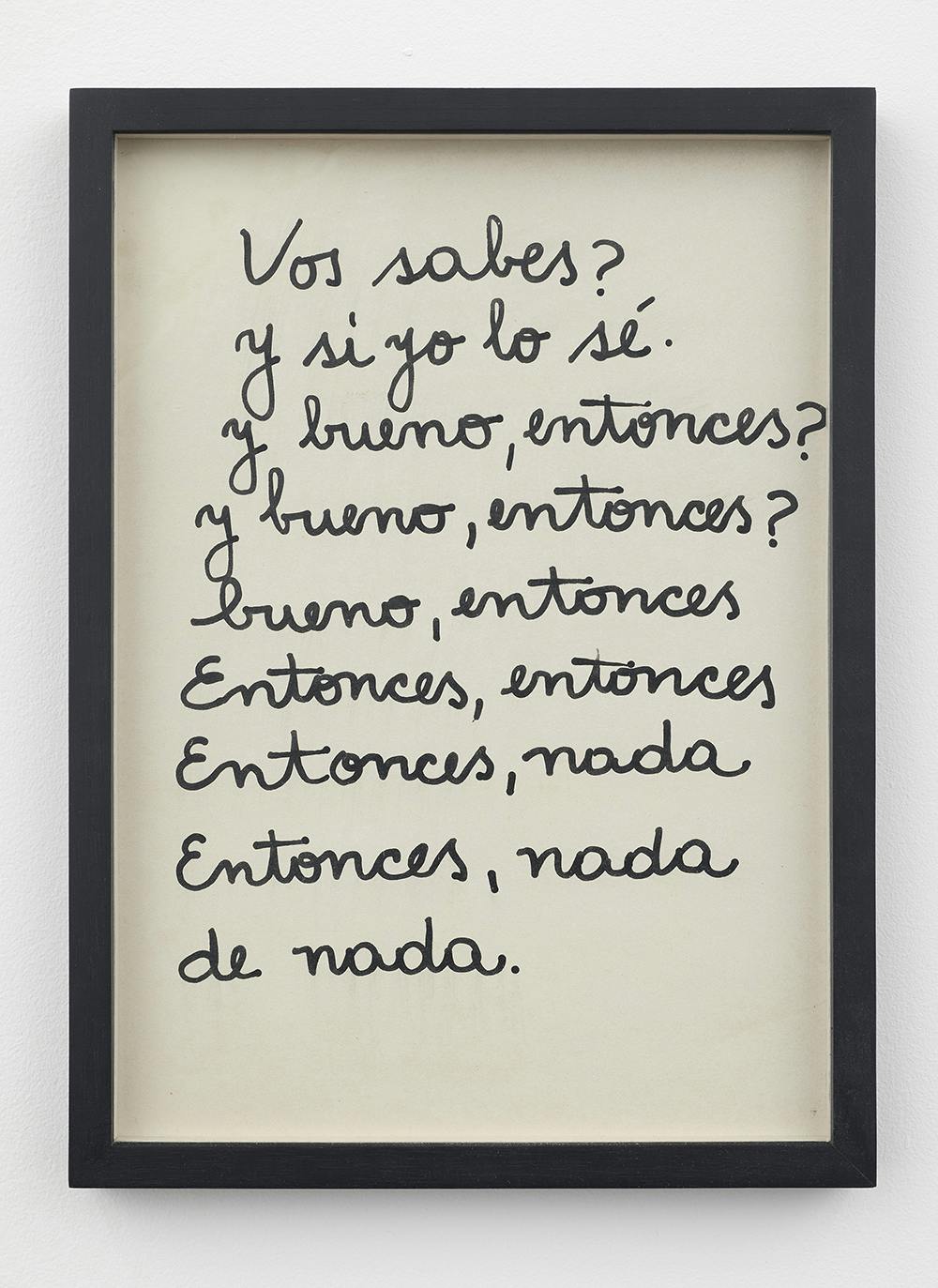 A white page with black cursive text is mounted mounted in a black frame and hung on a white wall. The text reads, "Vos sabes? / Y si yo lo sé. / Y bueno, entonces? / Y bueno, entonces? / bueno, entonces / Entonces, entonces / Entonces, nada / Entonces, nada / de nada." (In English the text translates to, “You know? / And if I know. / And well, then? / And well, then? / Well, then / Then, then / Then, nothing / Then, nothing / you're welcome.")
