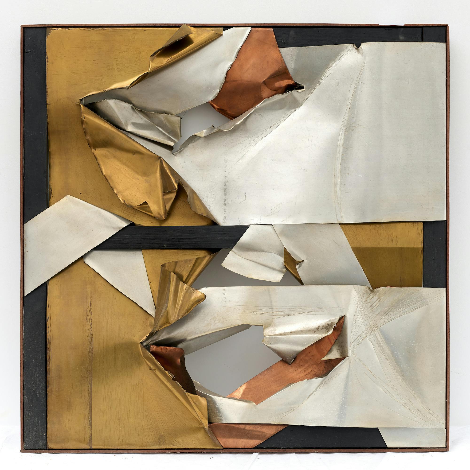 A rectangular artwork is displayed against a white wall. Wooden stretcher bars painted black compose the outer edges and horizontal center line of the work. Wrapped around, over, and under these are several layers of bronze-, silver-, and gold-colored sheet metal. These various surfaces are interwoven among one another, their jagged edges curling upward. In two places—above and below the center stretcher bar, respectively—gaps between the layers of metal appear, revealing the wall behind the work.