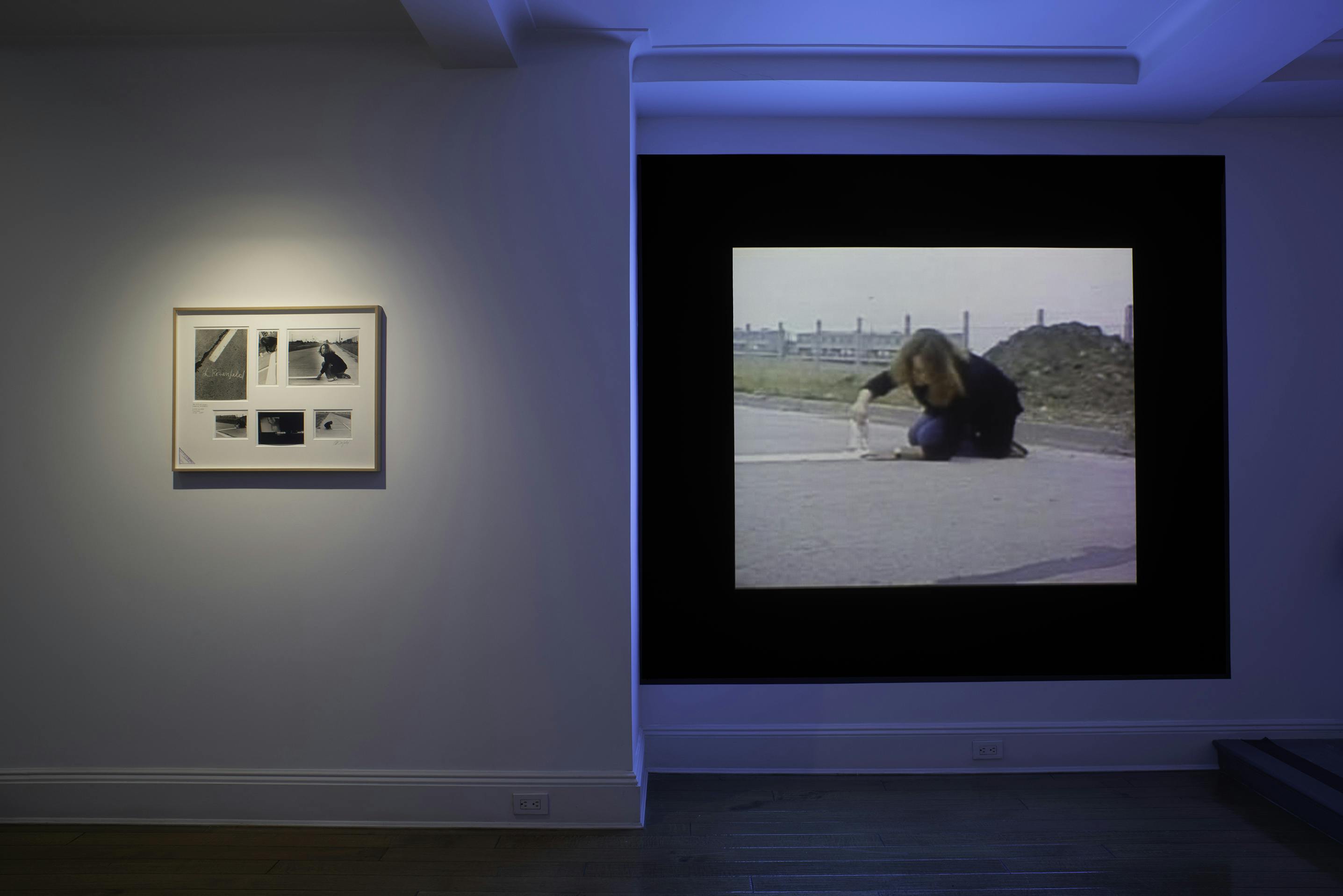 Front view of mounted and framed photographs and a large video projection.