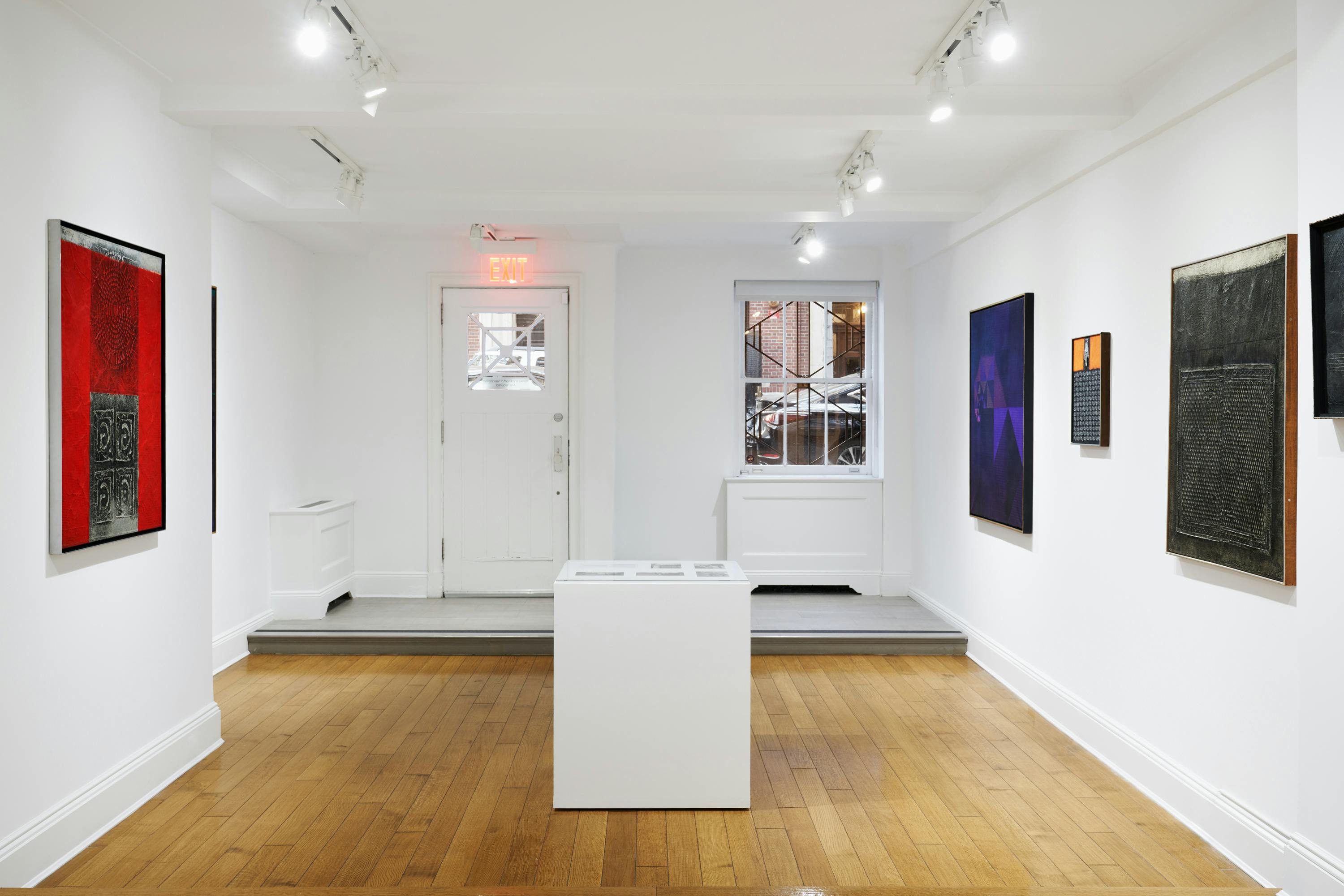 Installation view of José Antonio Fernández-Muro: Geometry in Transfer exhibition showing four paintings and one vitrine.