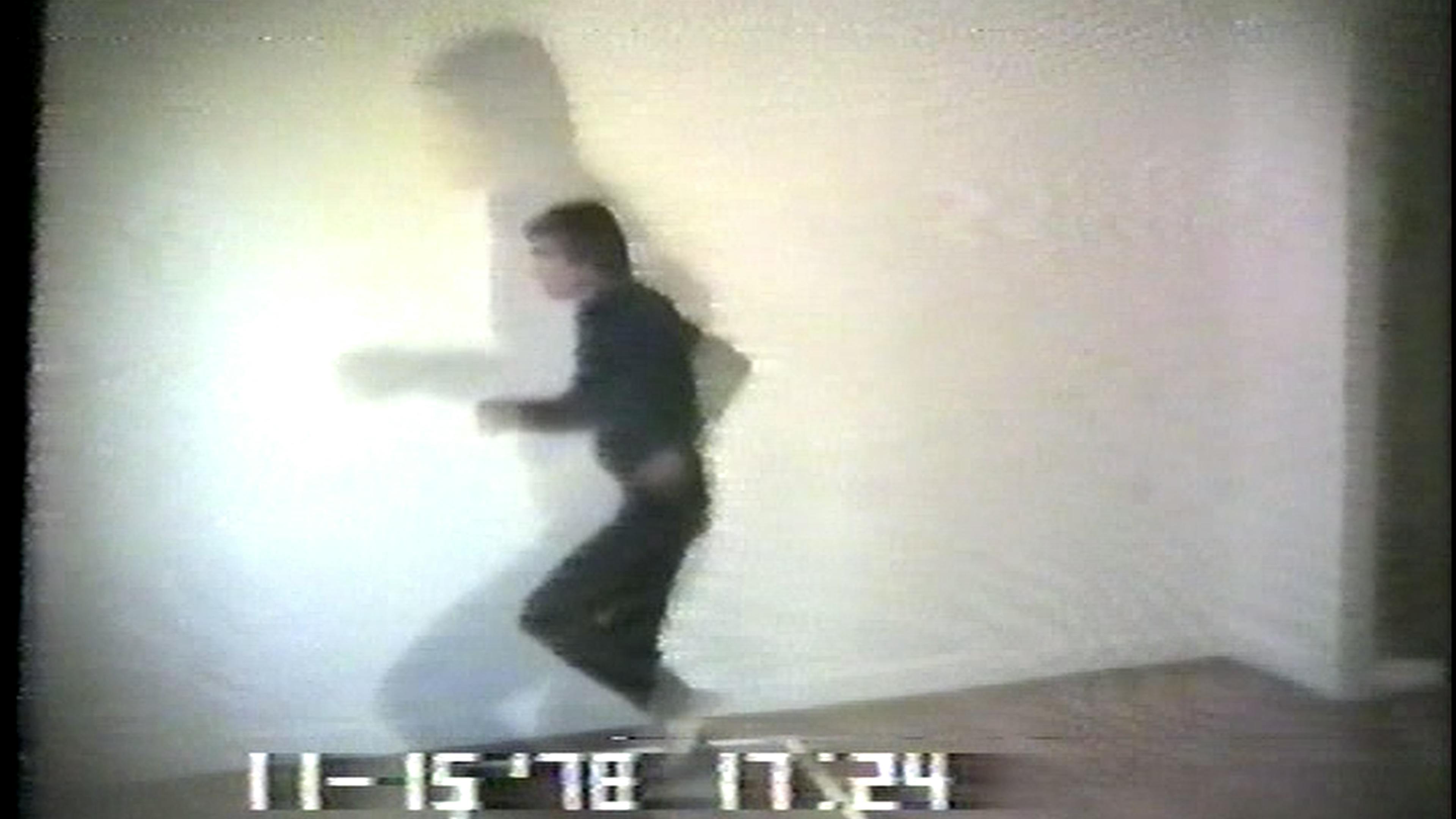 Film still of man running in black clothes