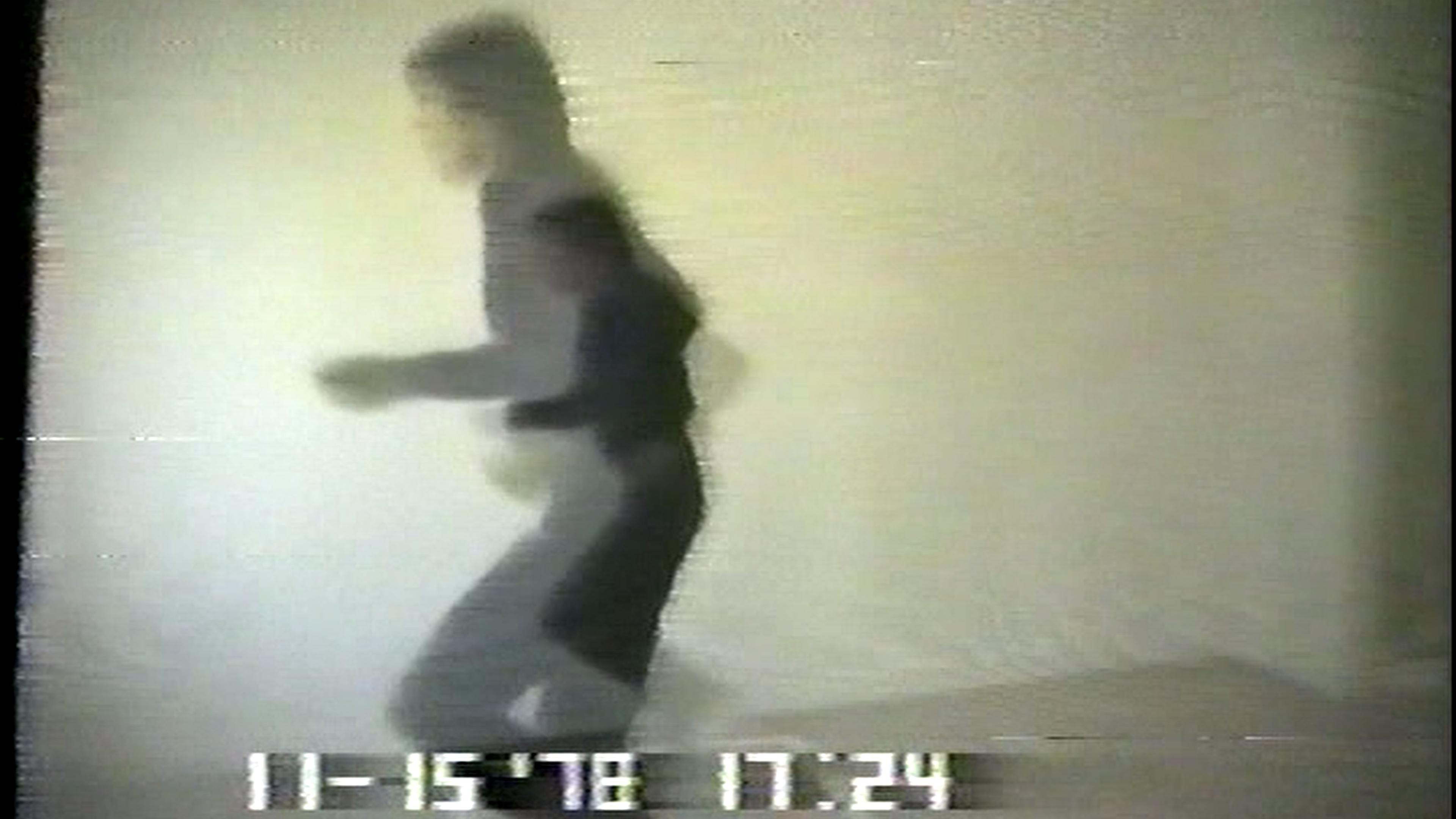 Film still of man running in black clothes