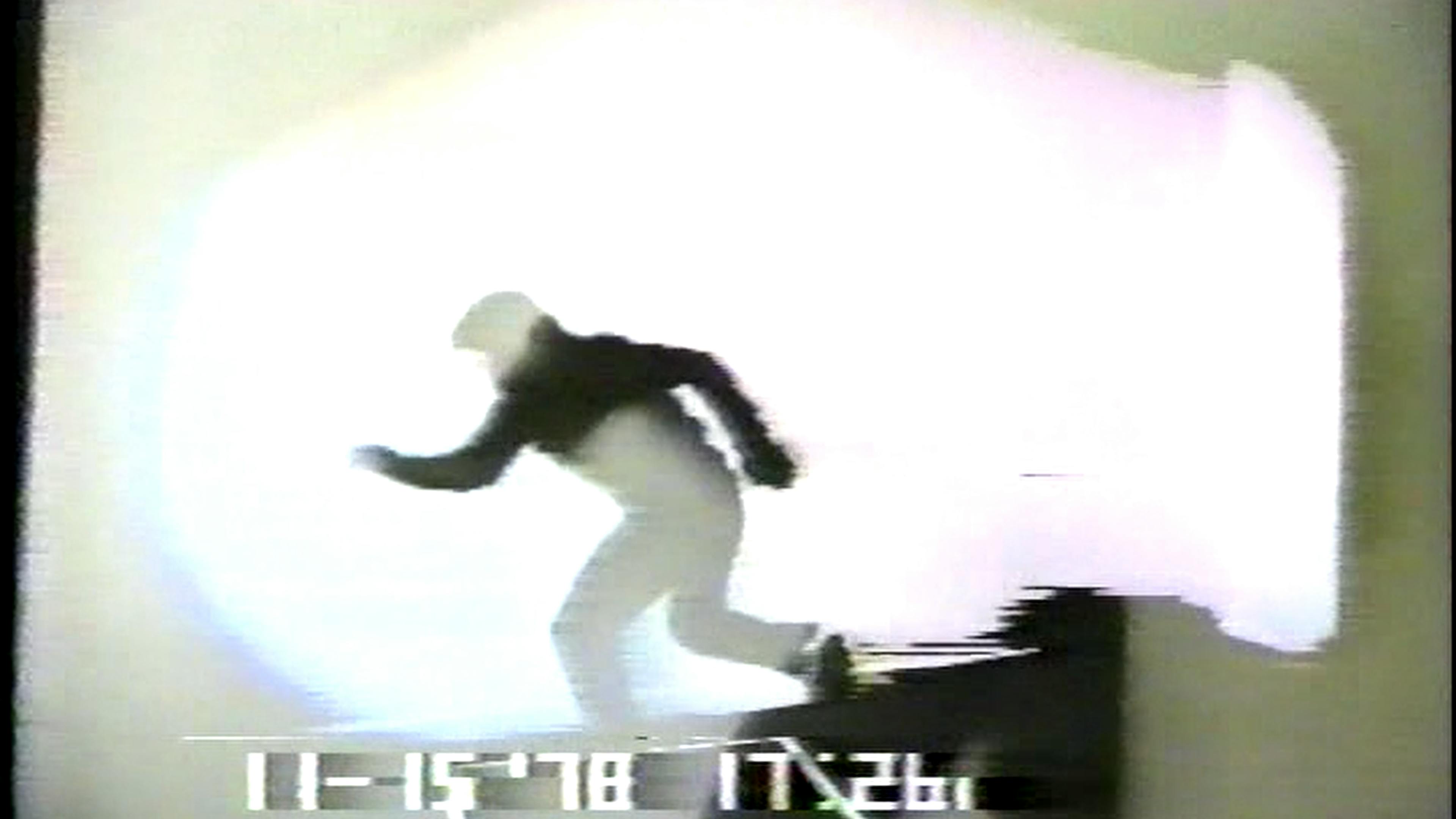 Film still of man running in black clothes