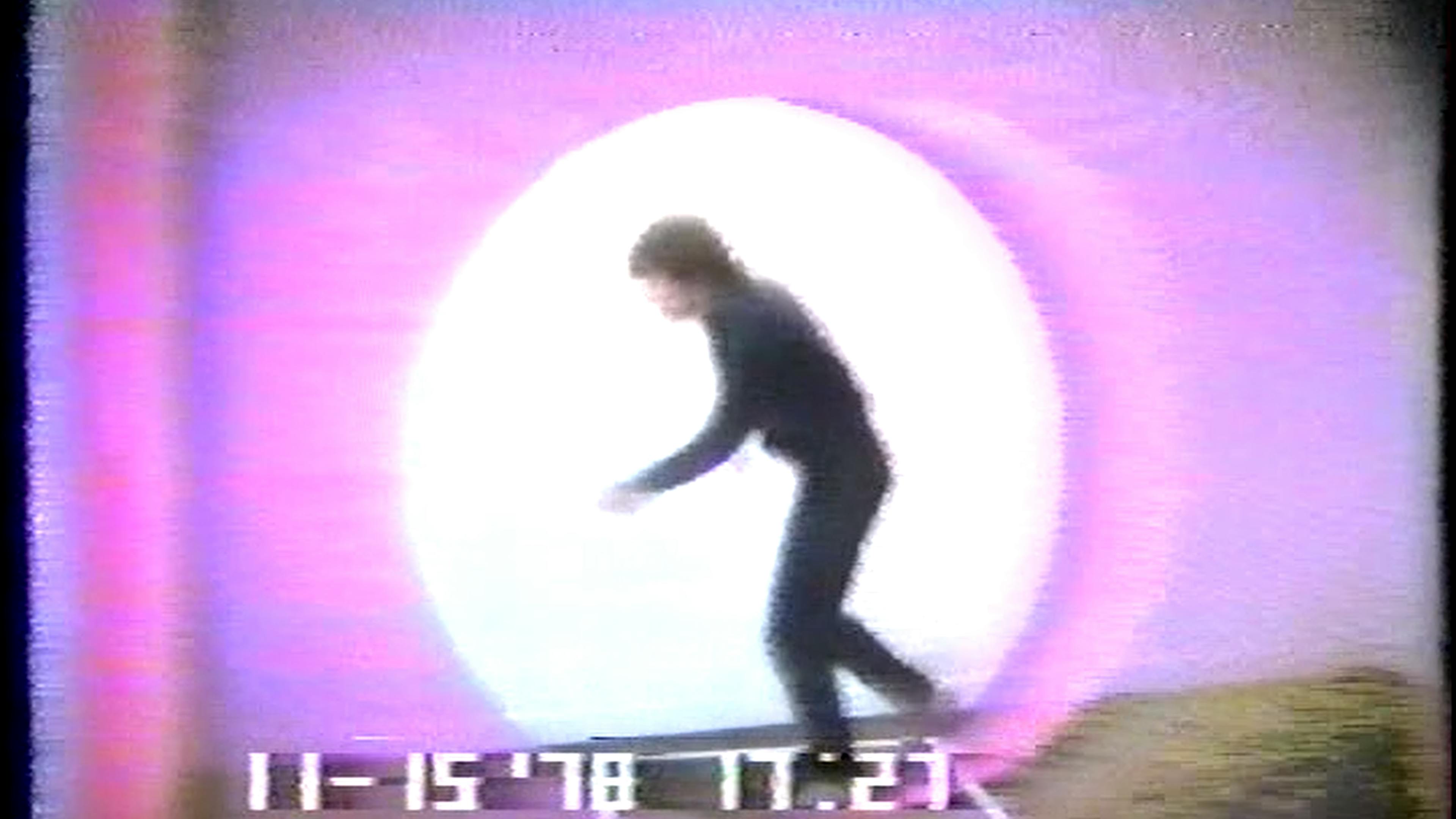 Film still of human figure running in black clothes with pink light hallo