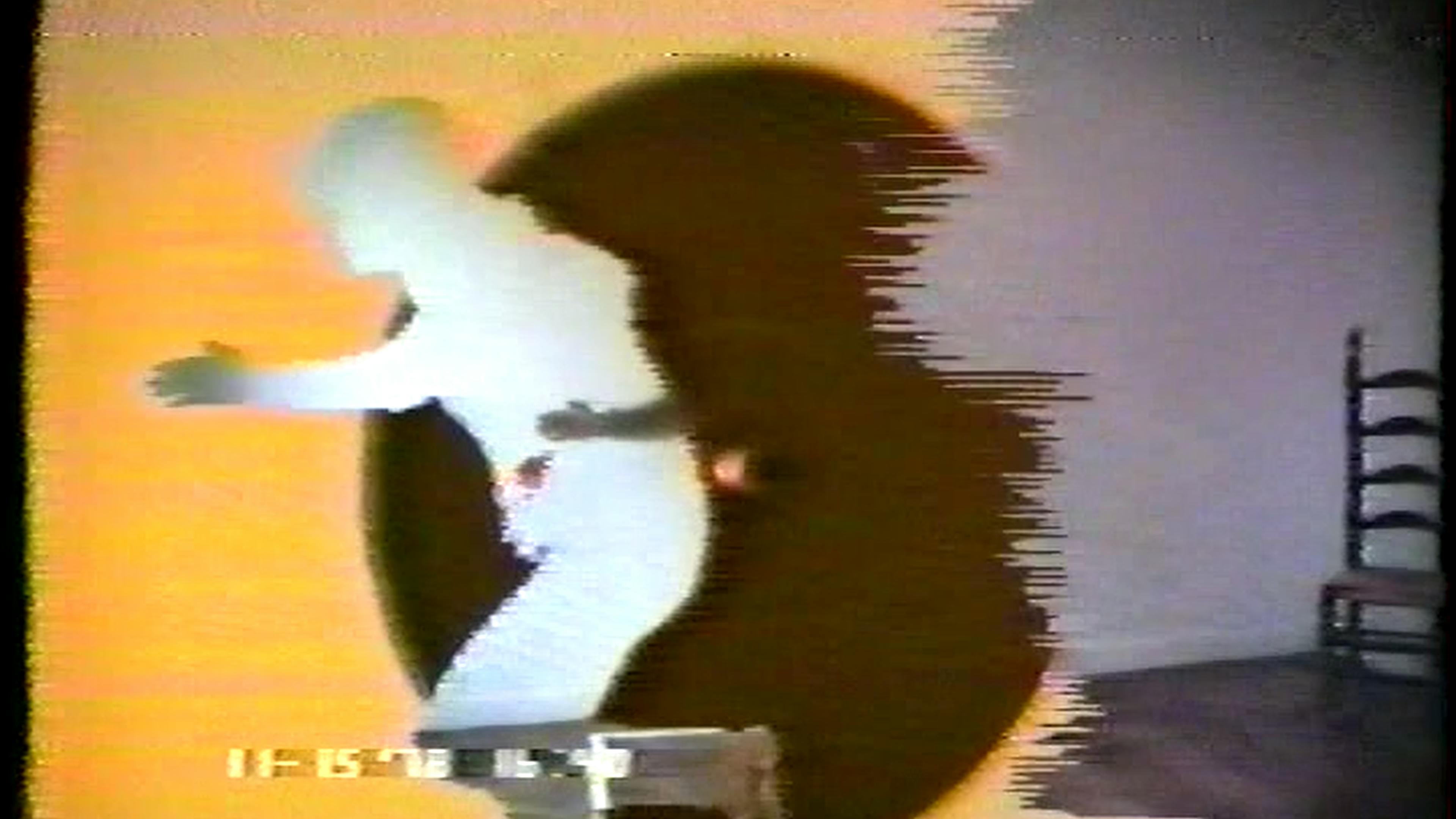 Film still of human figure running in black clothes with orange light hallo