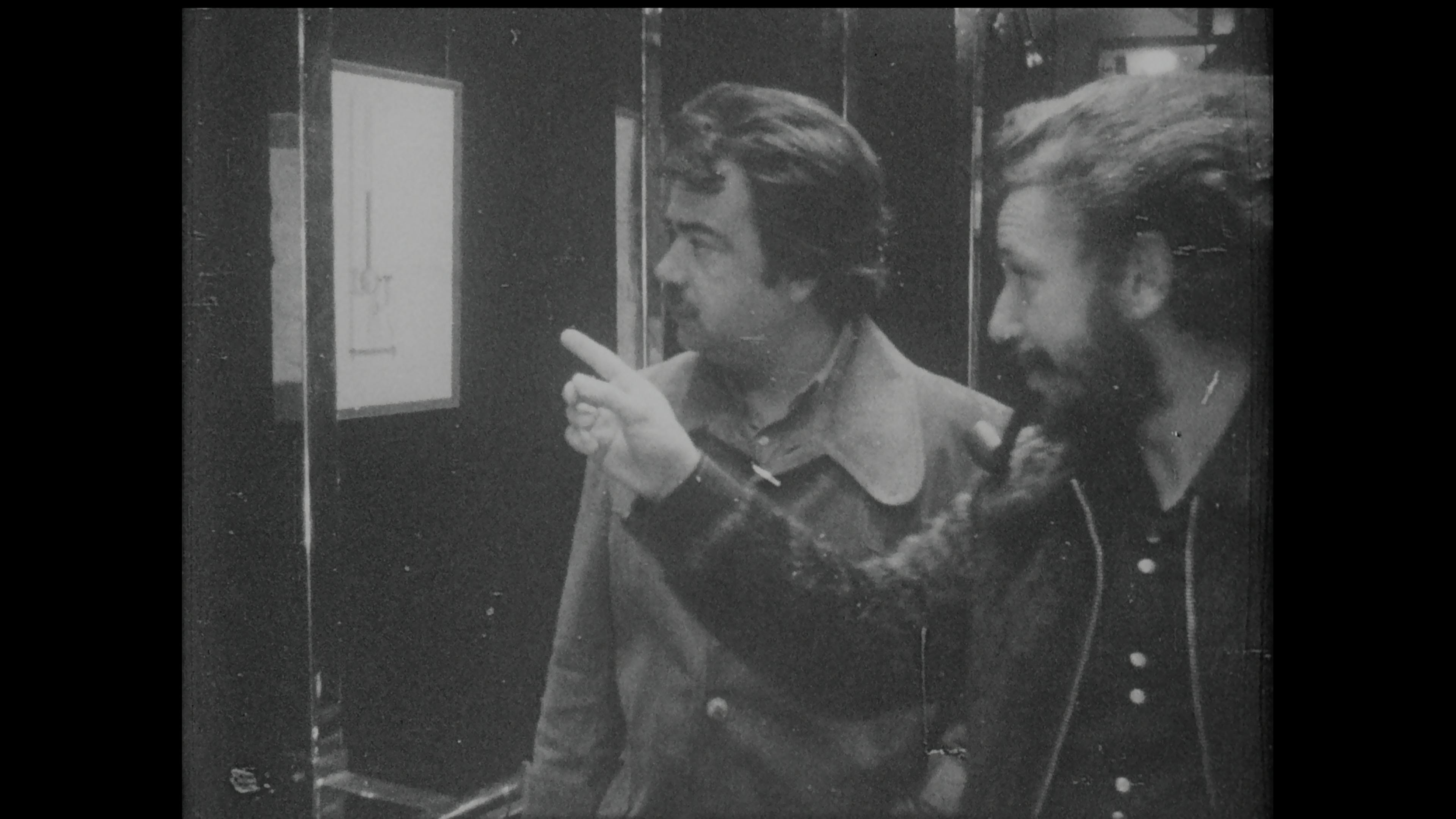 Black-and-white film still of two men talking