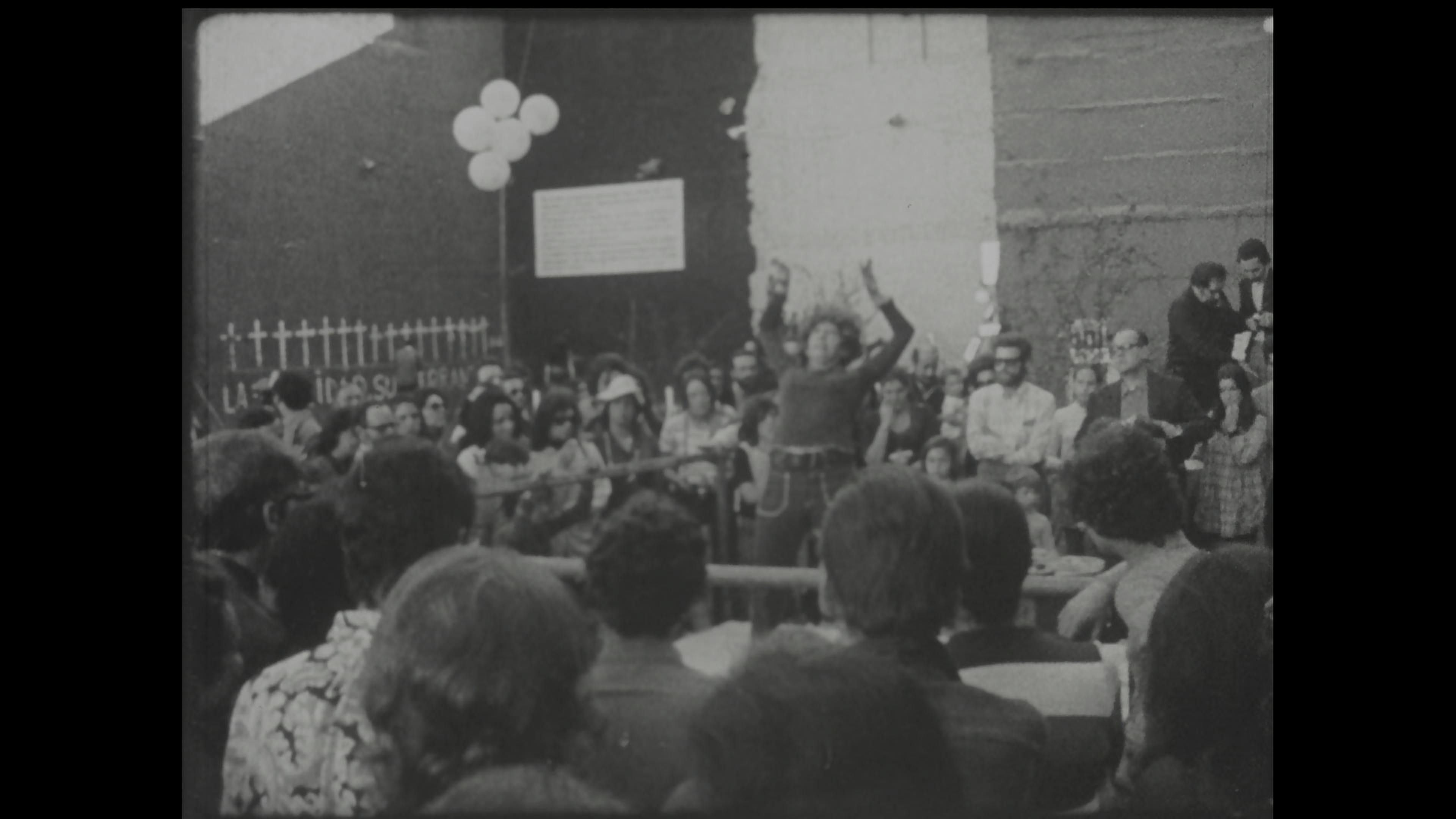 Black-and-white film still of public art event