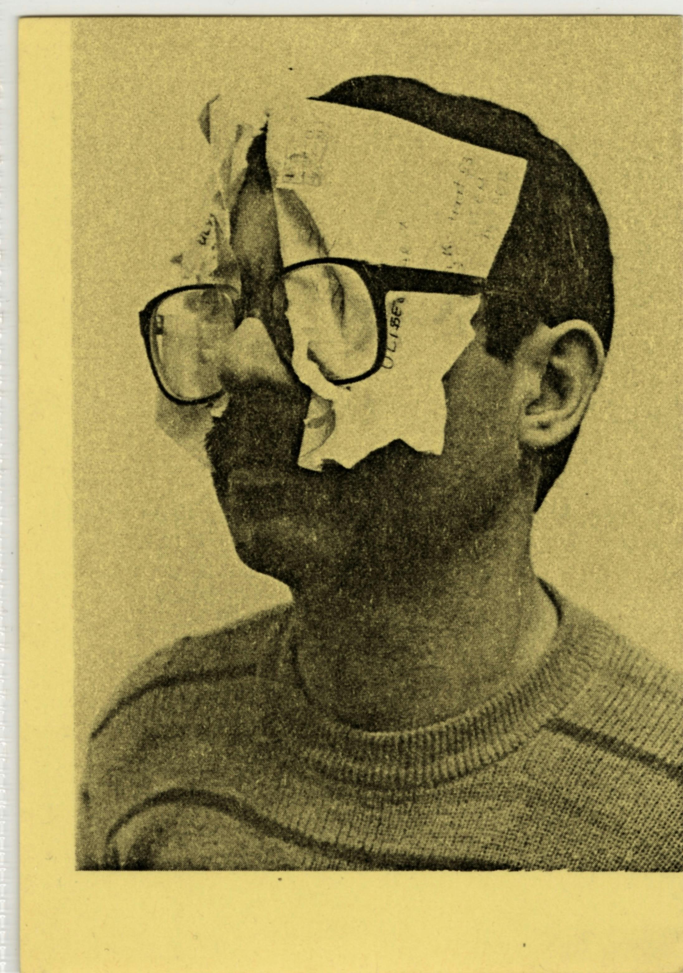 A horizontal yellow postcard printed with a black image of a man in three quarter view. He is wearing glasses. Crumpled pieces of paper have been stuffed behind each lens.