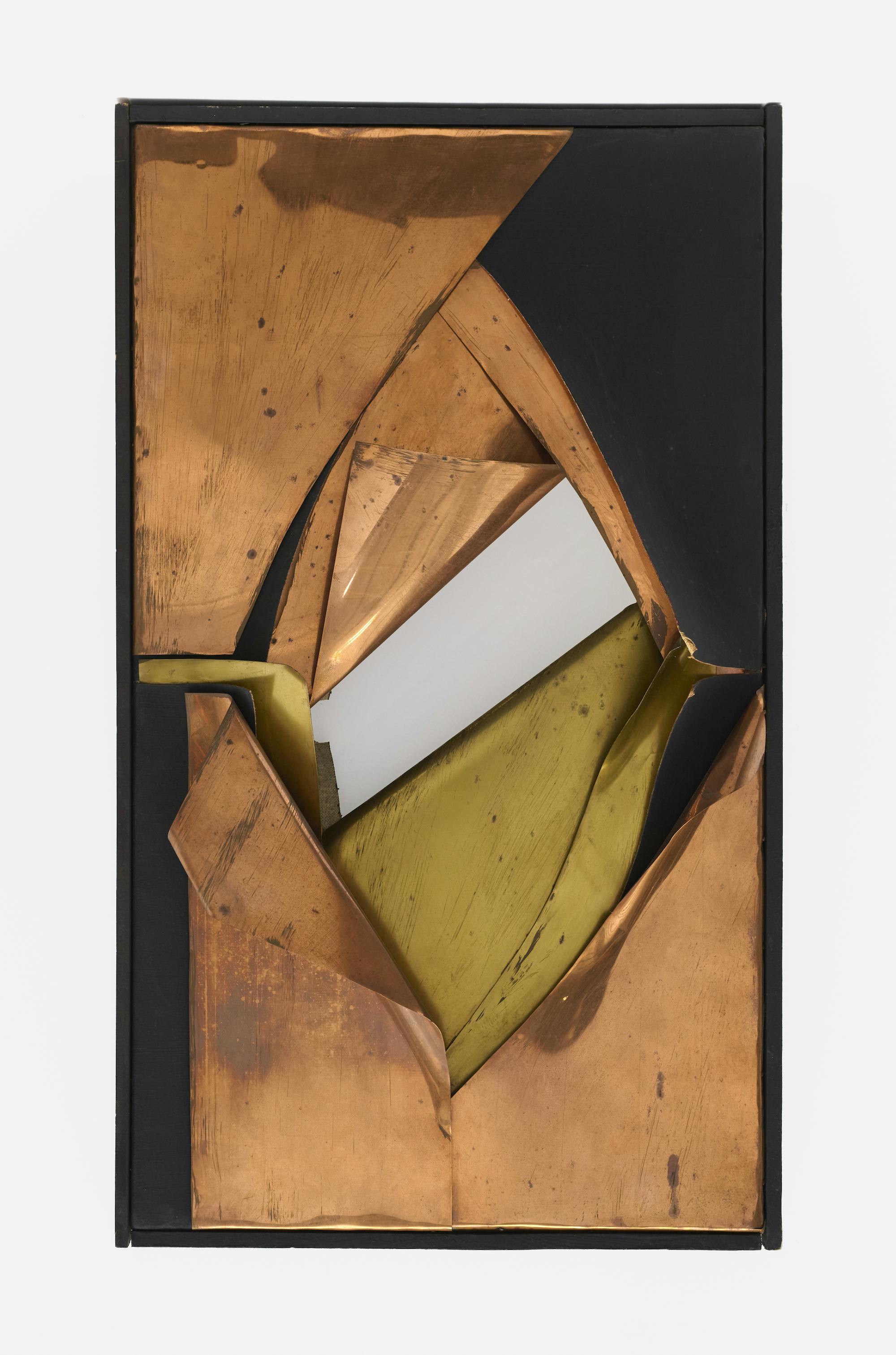 A tall rectangular artwork is displayed against a white wall. Inside the frame, several layers of bronzed sheet metal and one layer of black-painted canvas have been cut away or folded back to reveal a diamond-shaped gap in the center of the work, which gradually narrows through the layers into a small diagonal strip of empty space, through which the wall behind the work is visible.