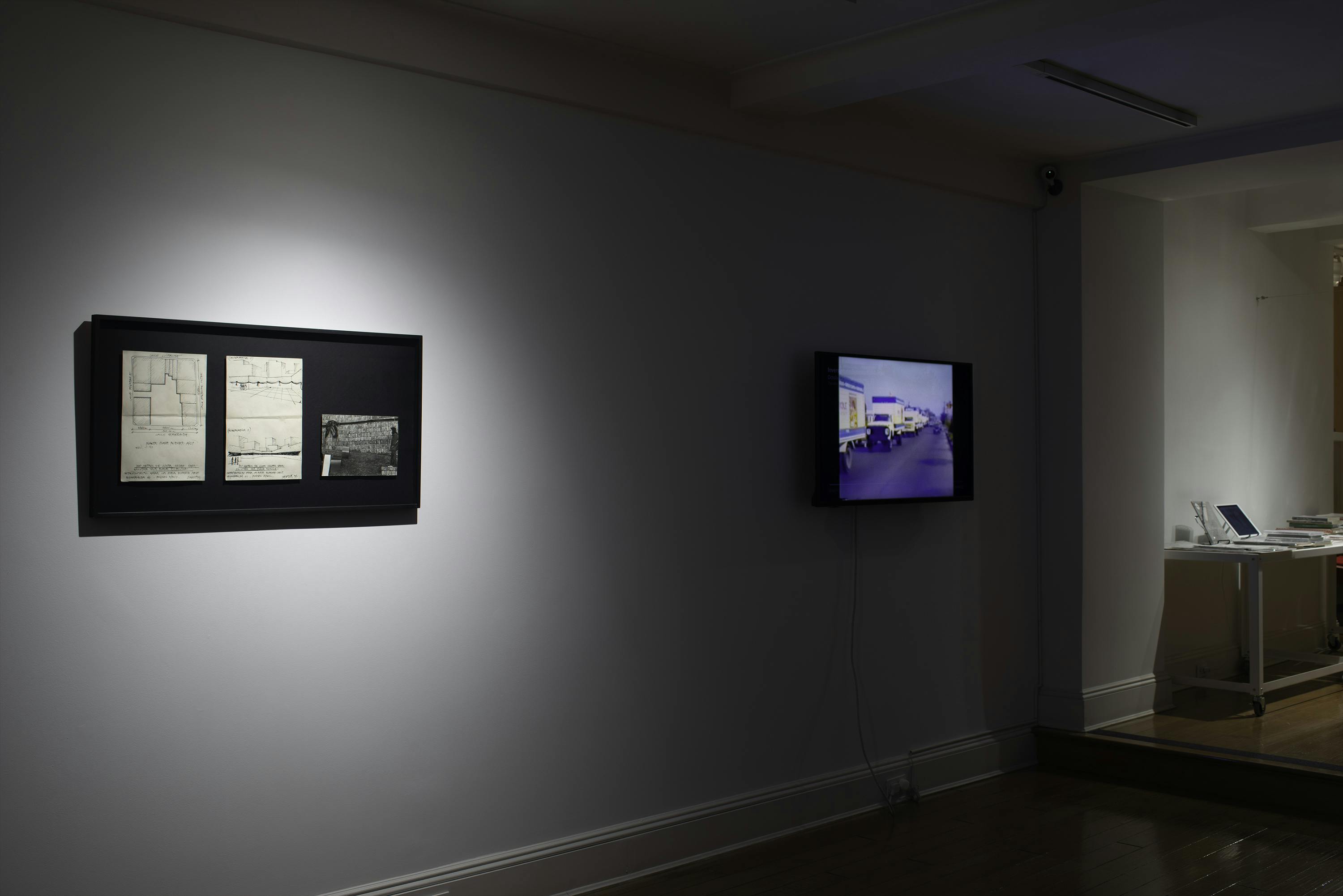 Right side view of mounted and framed original documents and a TV screen playing video.