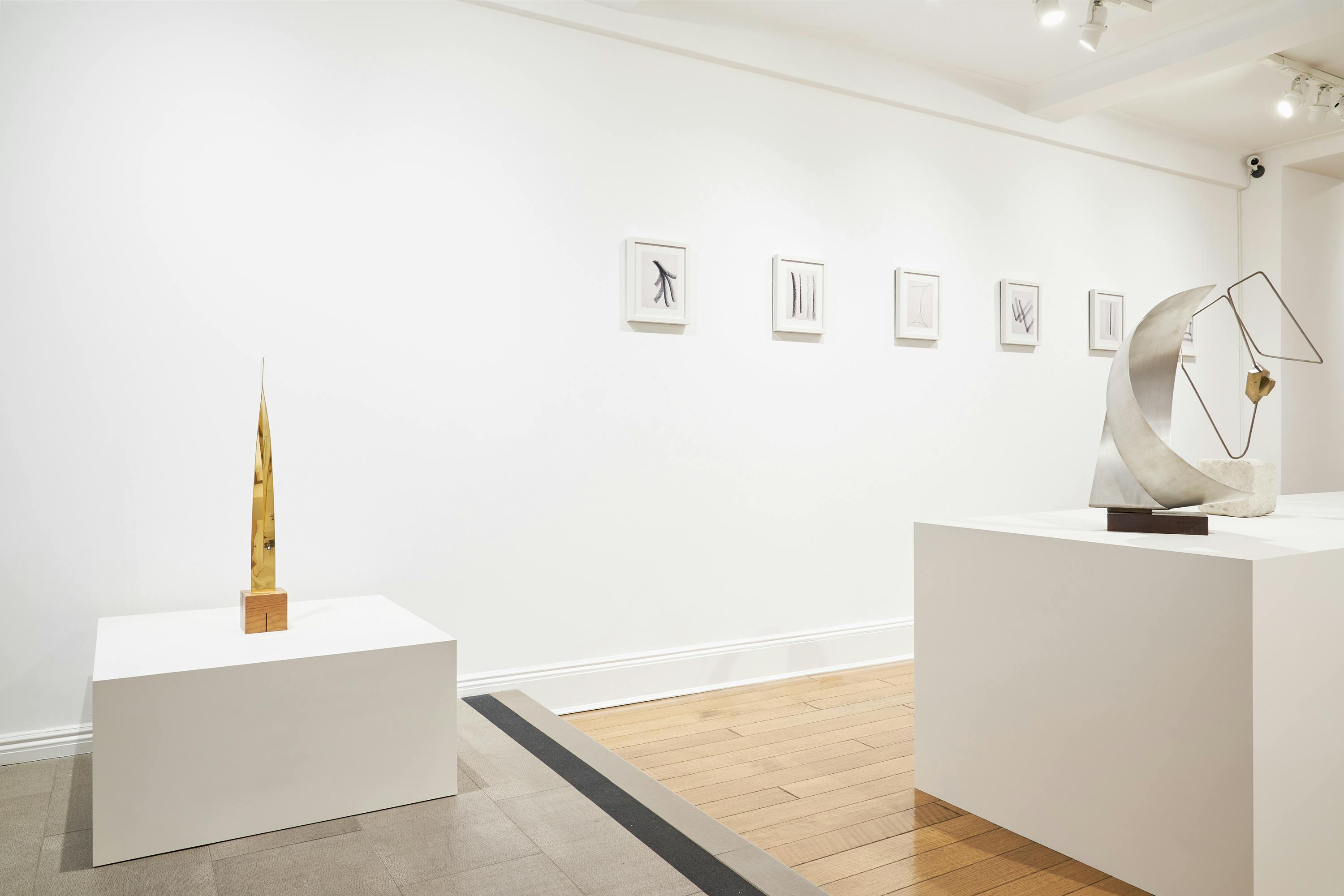Gallery view of From Surface to Space exhibition showing three free-standing sculptures and five wall-mounted drawings.