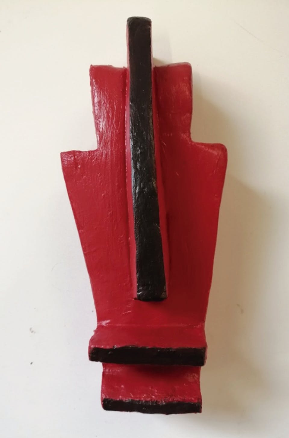 A geometric sculpture painted in red and black.
