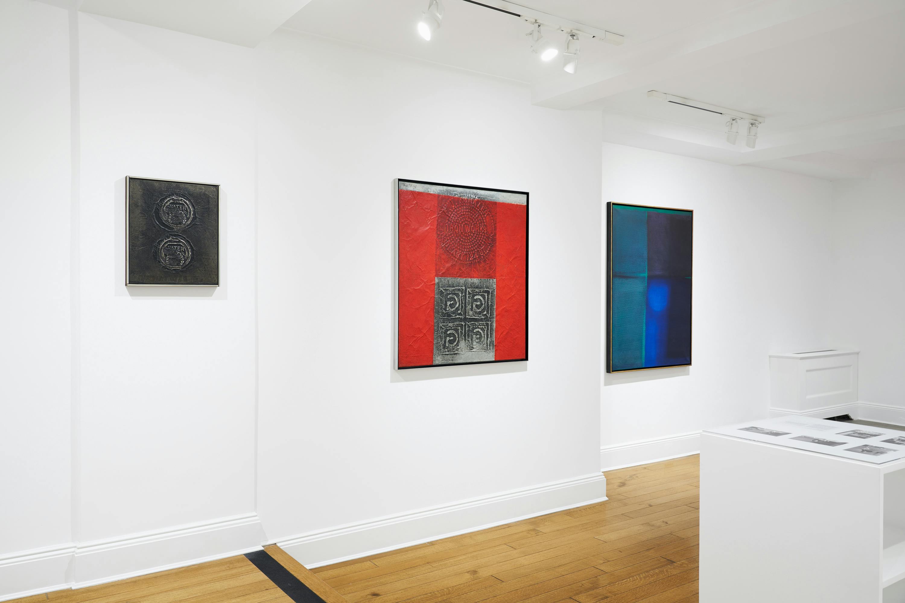 Installation view of José Antonio Fernández-Muro: Geometry in Transfer exhibition showing three paintings and one vitrine.