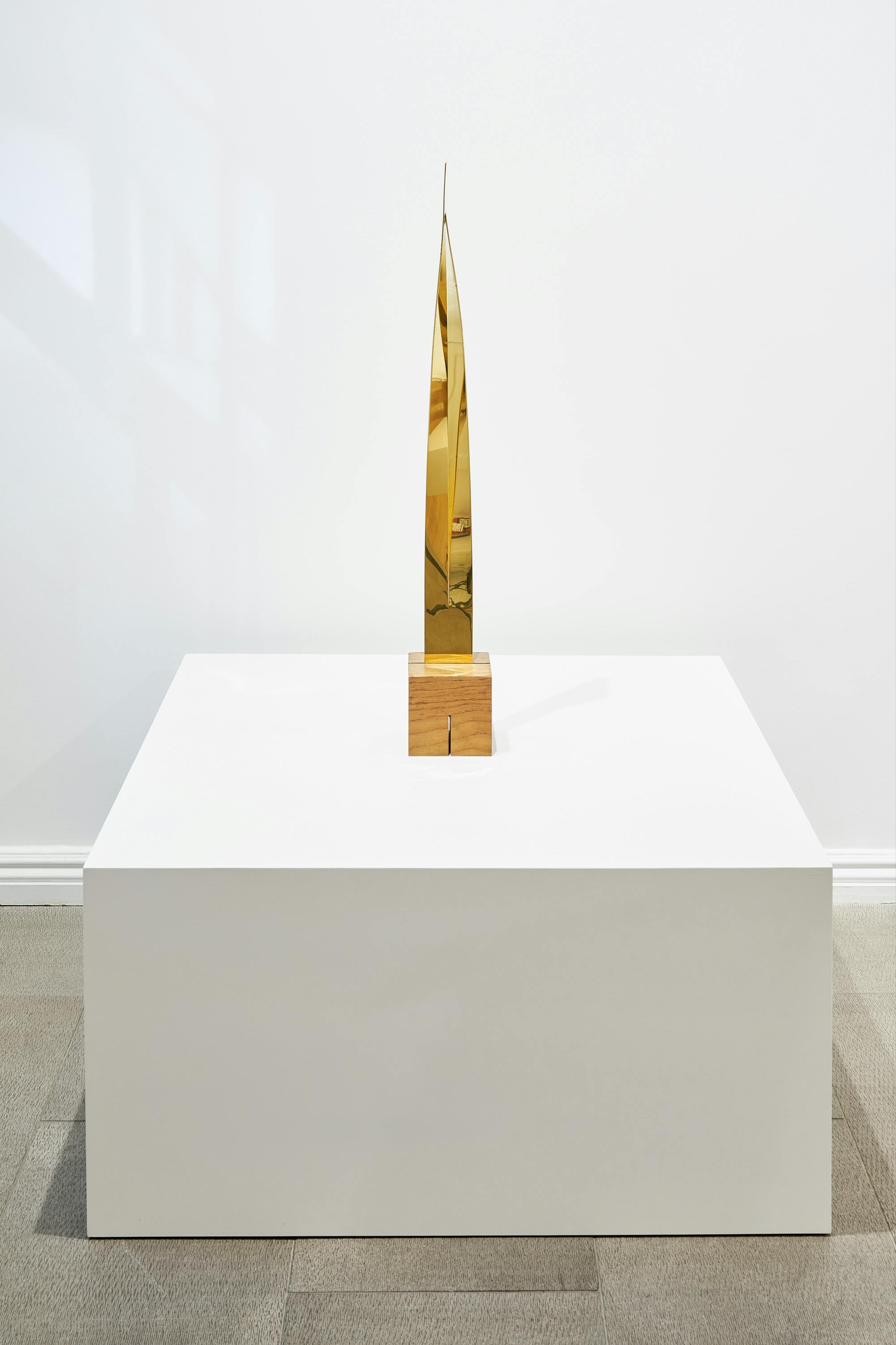 Gallery view of From Surface to Space exhibition depicting one gold-colored, abstract sculpture.