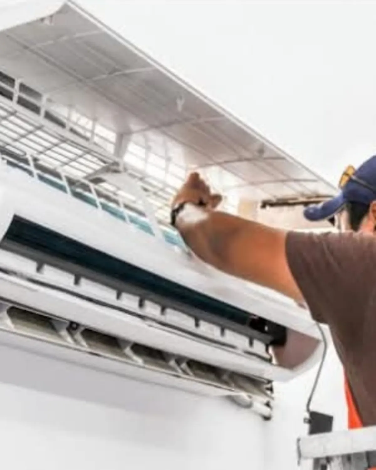 Andrew of Island Engineering servicing a wall-mounted air conditioning unit