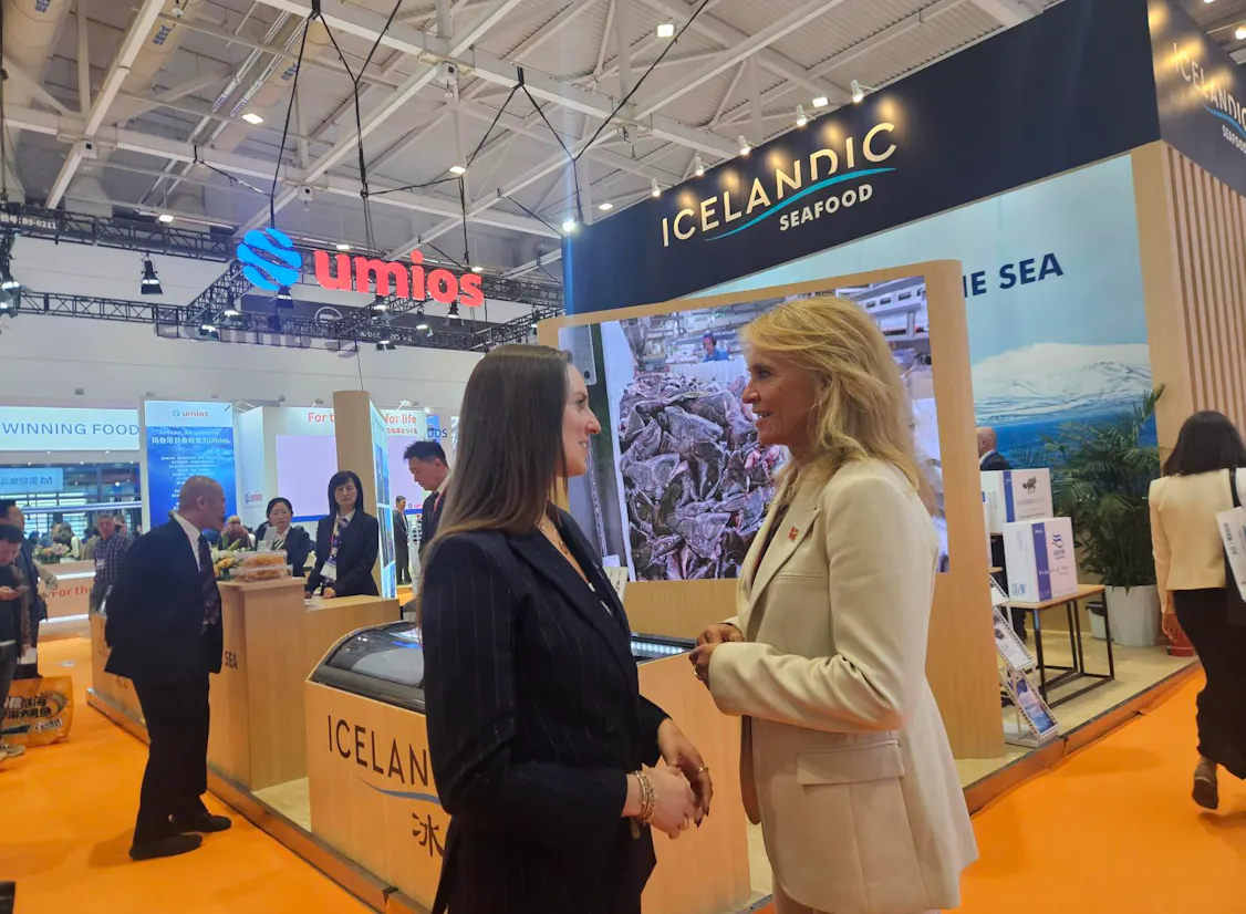 Minister for Foreign Affairs Þorgerður Katrín Gunnarsdóttir, in a white jacket, talks with a woman at Iceland’s stand at the China Fisheries & Seafood Expo in Qingdao 2026.