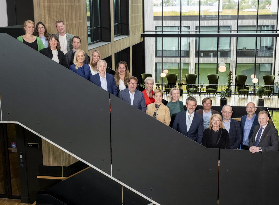 Members of the Export and Marketing Council at the Business Iceland office in Gróska, standing on the staircase inside the modern, glass-walled workspace.