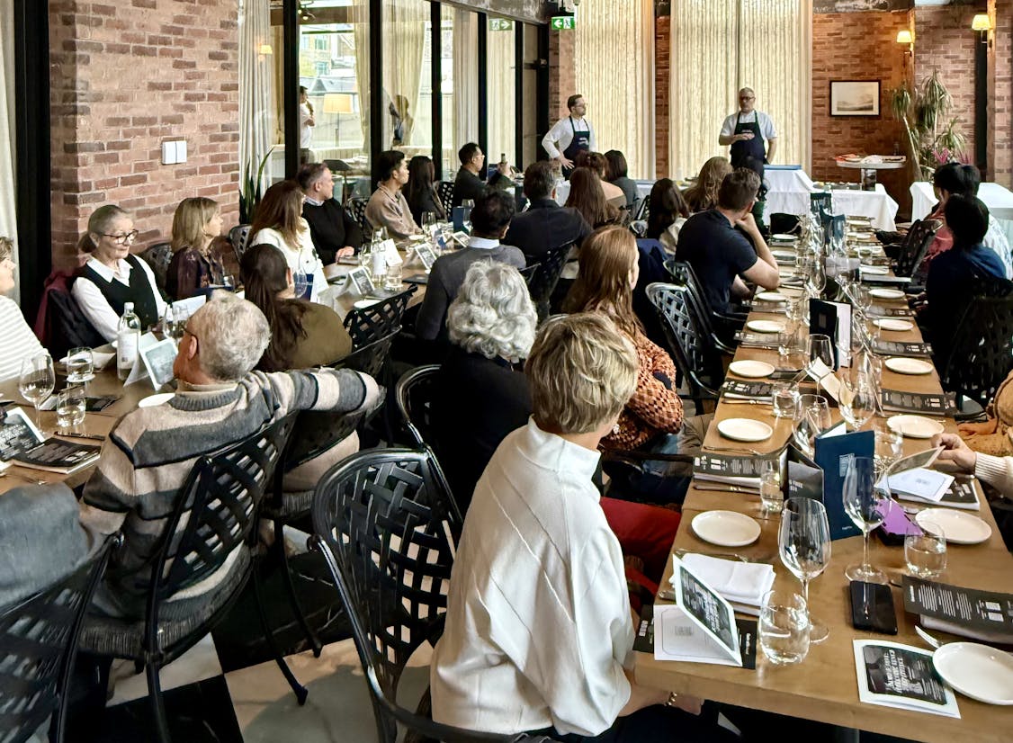 Gestir sitja til borðs á tveimur borðum á Demo & Dine viðburði Taste of Iceland hátíðarinnar í Toronto þar sem tveir íslenskir kokkar eru með sýnikennslu.