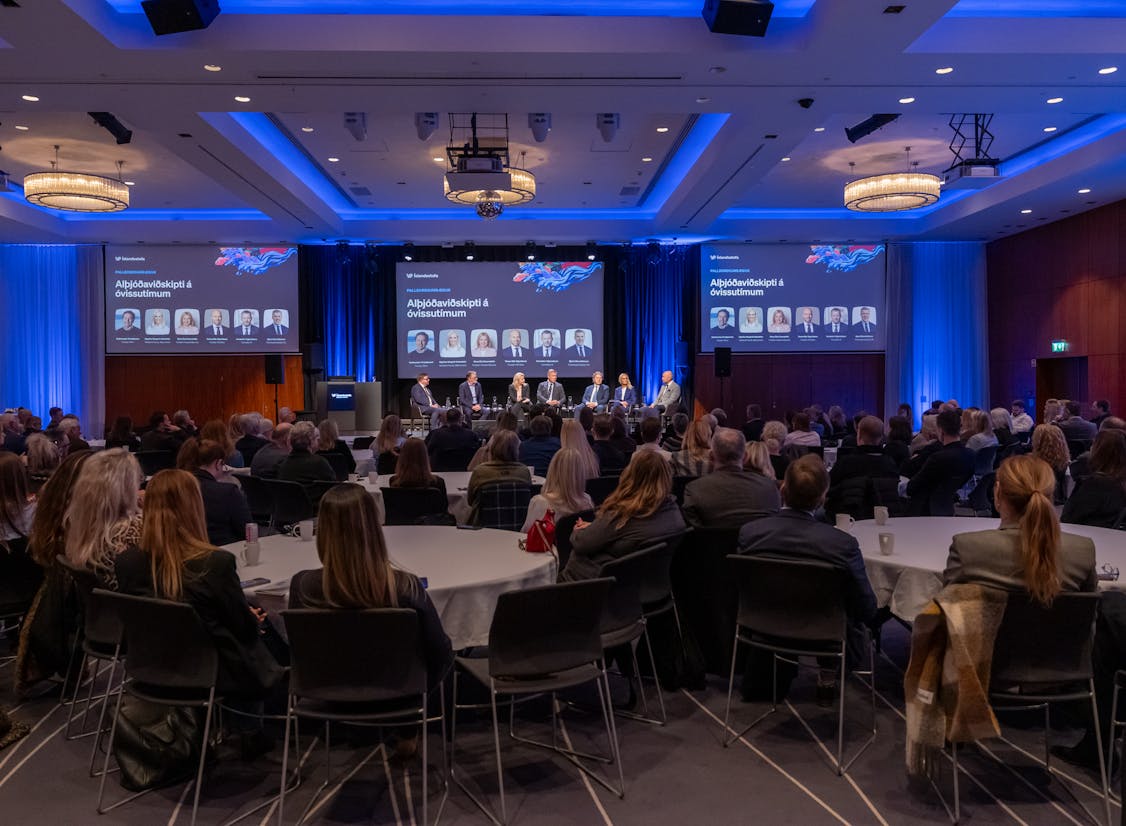 Gestir á ársfundi Íslandsstofu í sal á Hilton með panelþáttakendur í baksýn