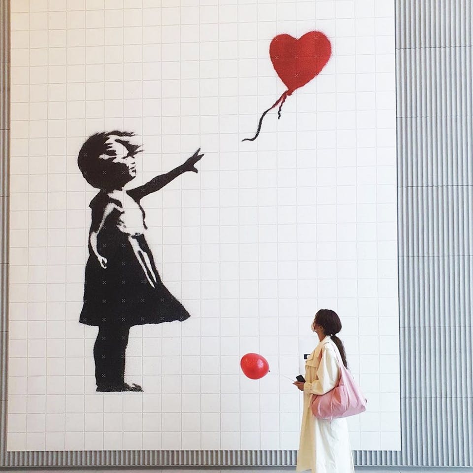 Banksy's Girl with balloon groot aan de muur met vrouw met ballon