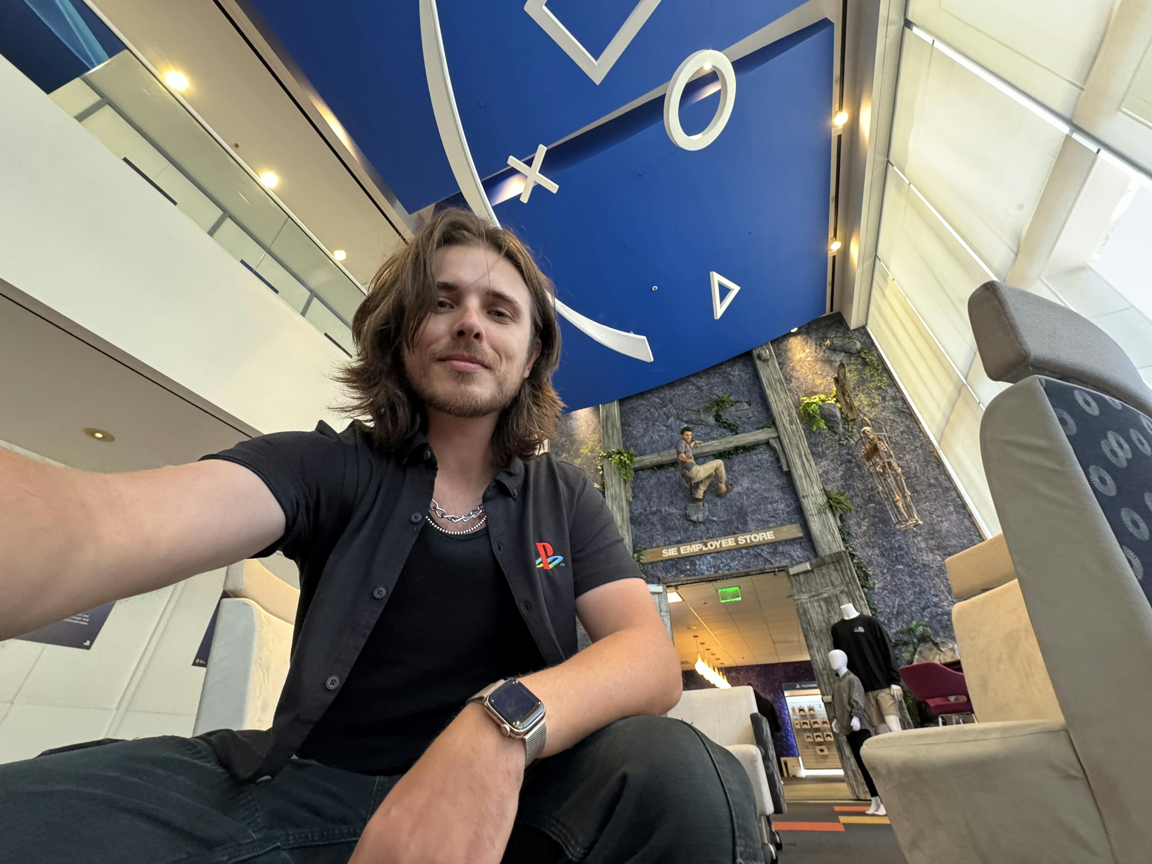 Selfie at the PlayStation headquarters in California. I'm wearing a PlayStation shirt and there are PlayStation symbols on the ceiling. 