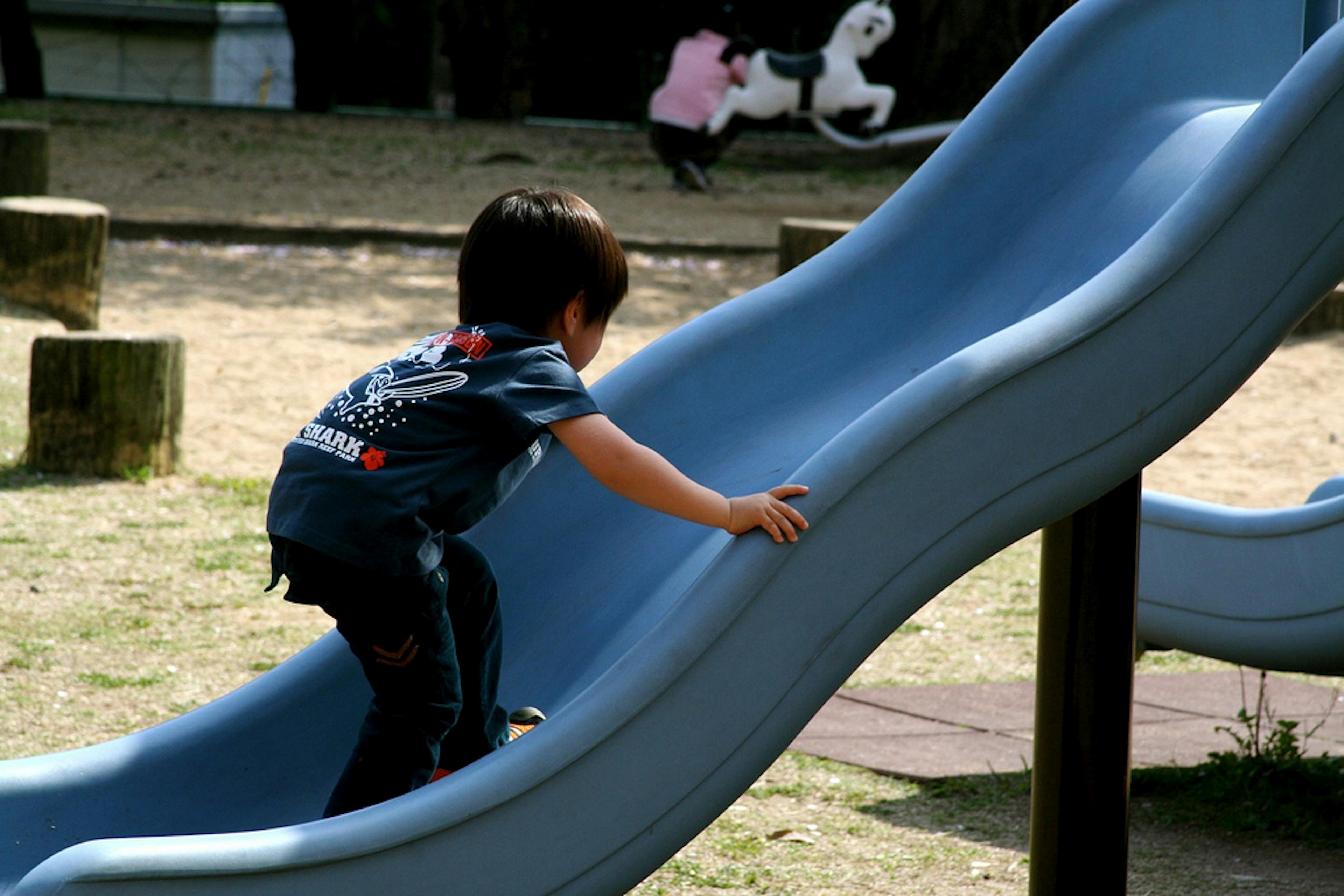 kid playing on a slide at the park