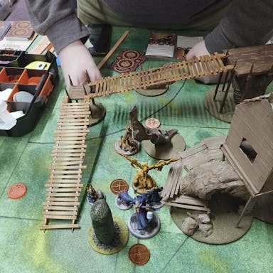 A Malifaux game and hands of a player