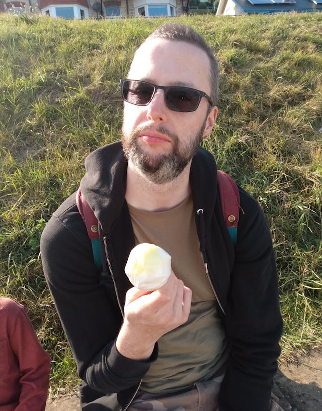 Handsome yet tired man eats ice cream on holiday