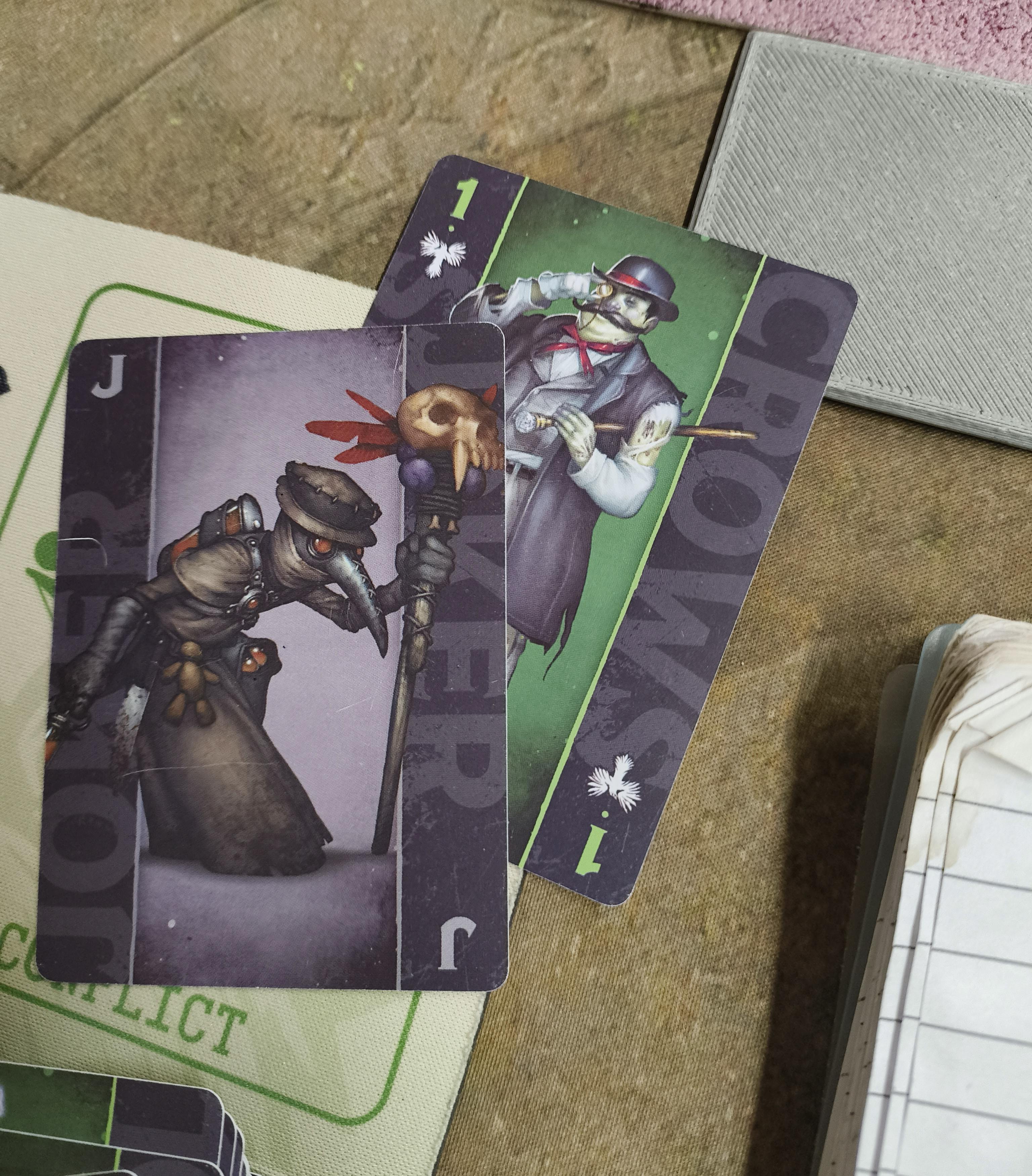 A Black Joker and a 1 card from a Malifaux fate deck.
