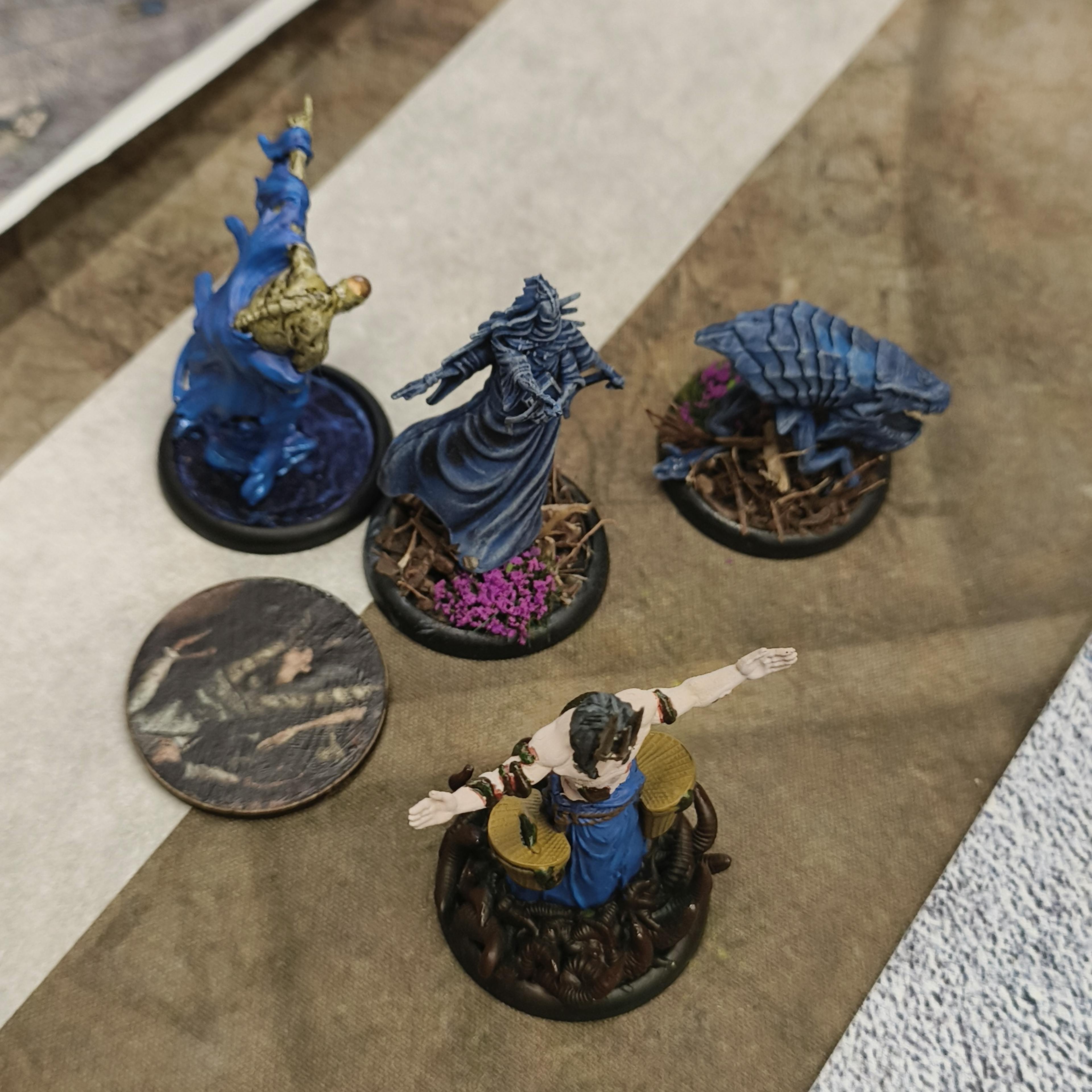Some buried Malifaux models, at the side of the board.