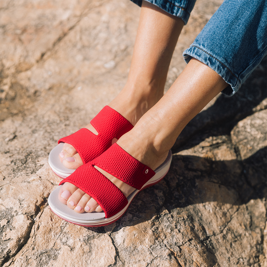 Rote Pantolette am Fuß gezeigt