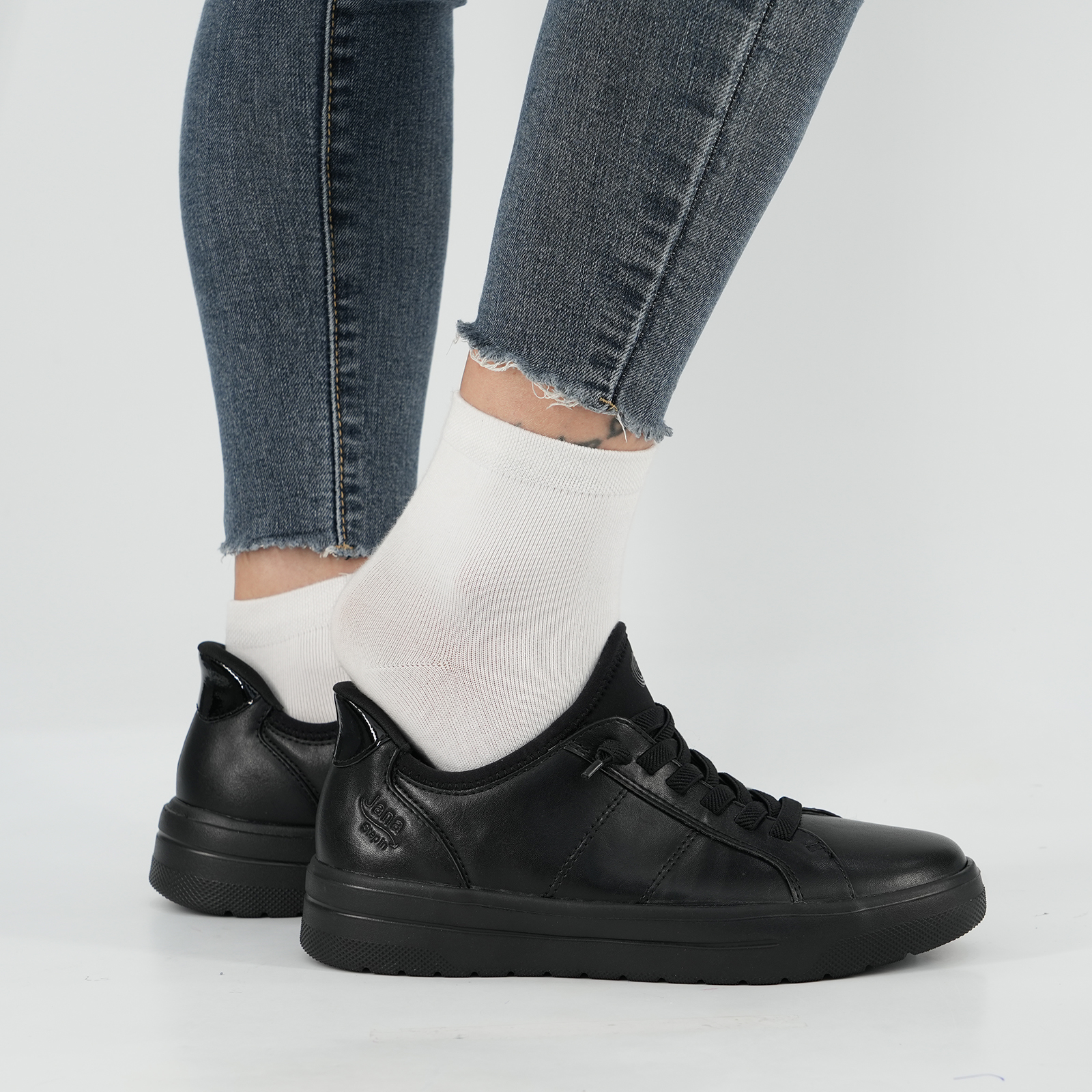 Person steigt freihändig in schwarzen Jana Schuh – bequemes Anziehen ohne Bücken dank Step in Technologie.