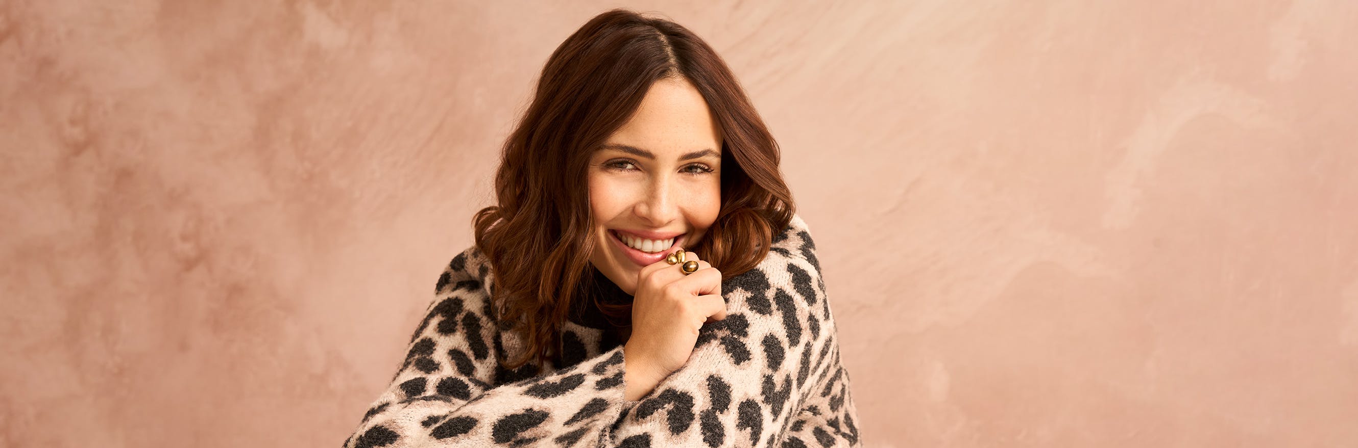 Lächelndes Model mit einem Pullover mit Leopardenmuster